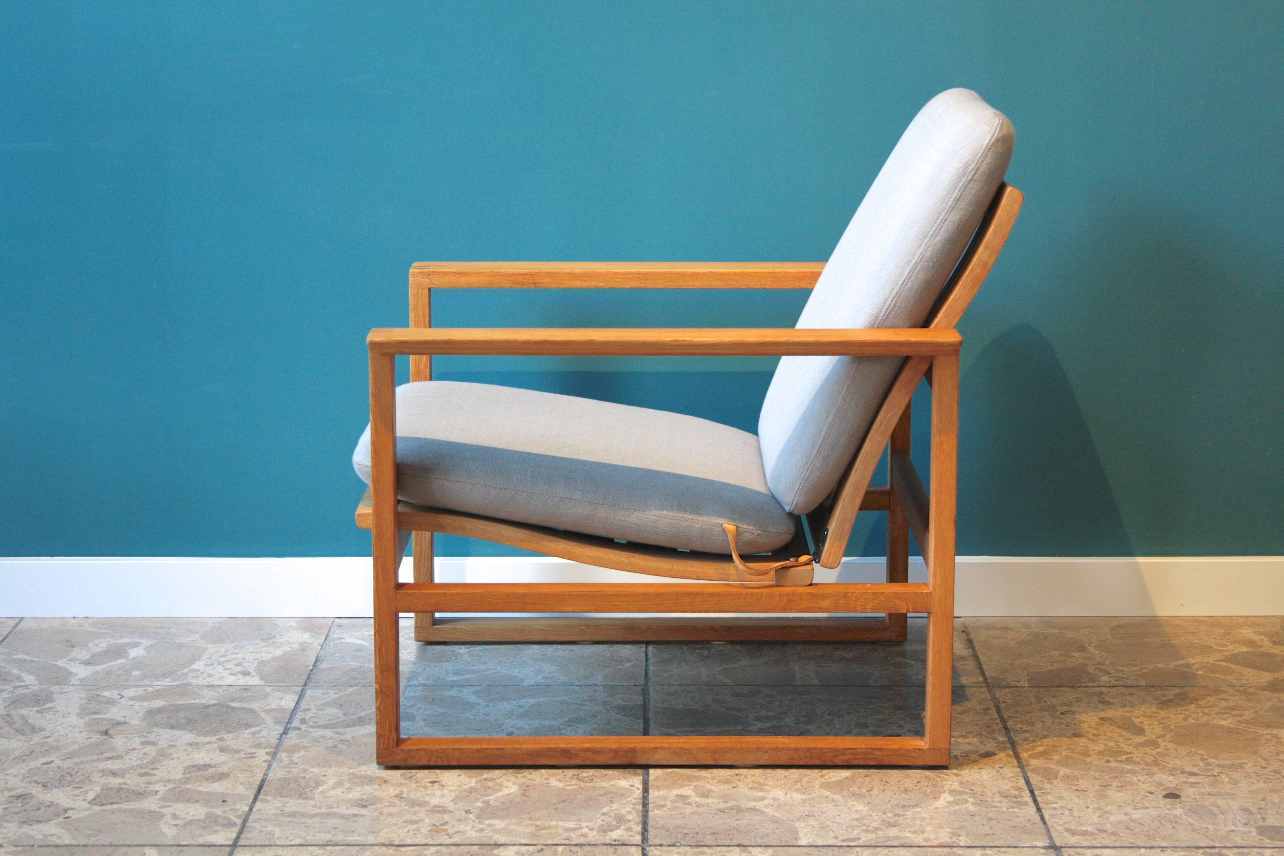 Børge Mogensen designed the model 2256 lounge chair in 1956 for Fredericia. The chair features a cubic frame made of solid oak with finger joints. The original cushions have been re-upholstered in a grey linen fabric and the seat belts and leather
