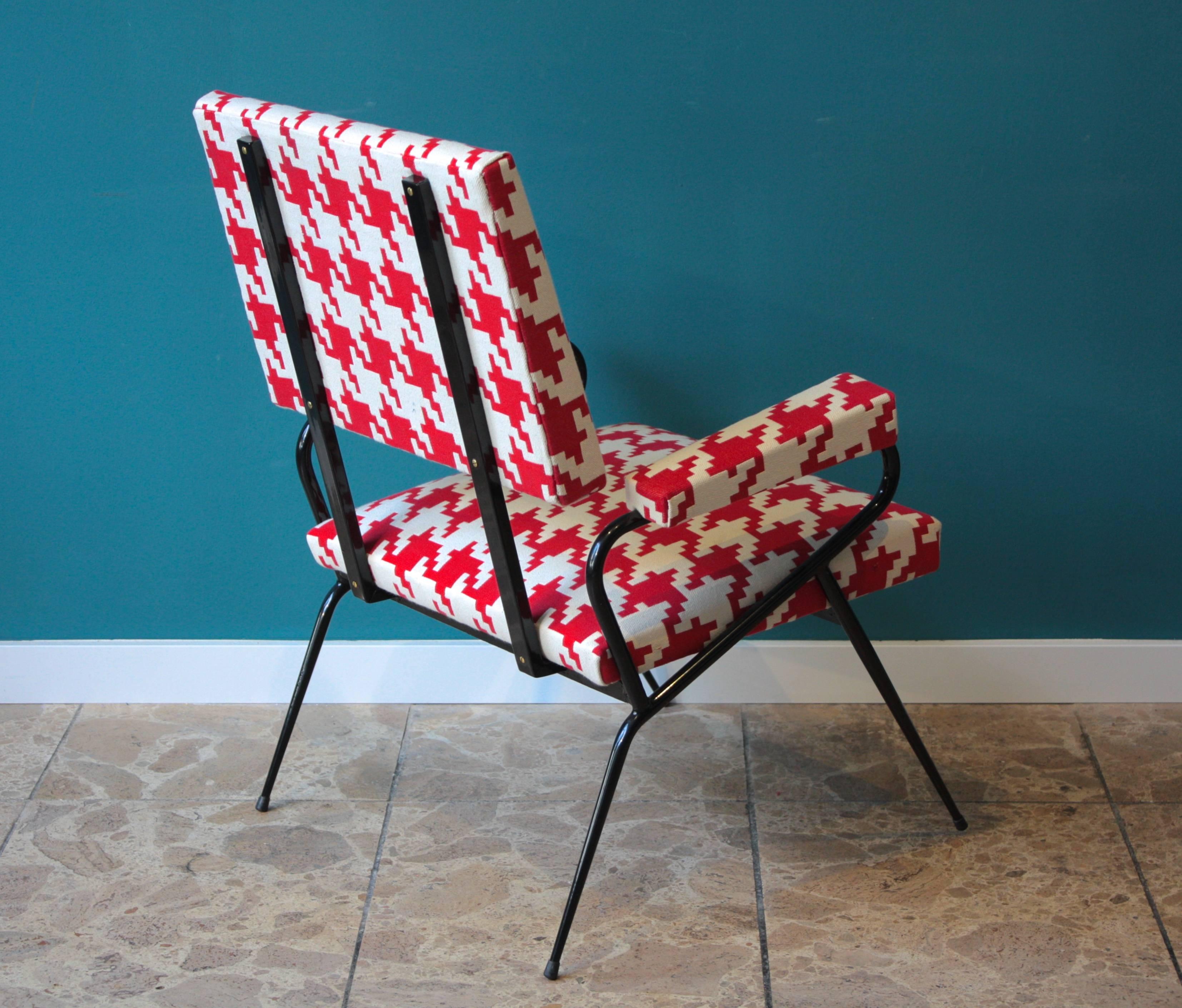 This Italian lounge chair was produced in the 1950s. It features a metal structure which has been relacquered. The chair has been reupholstered with a red and white houndstooth patterned fabric.