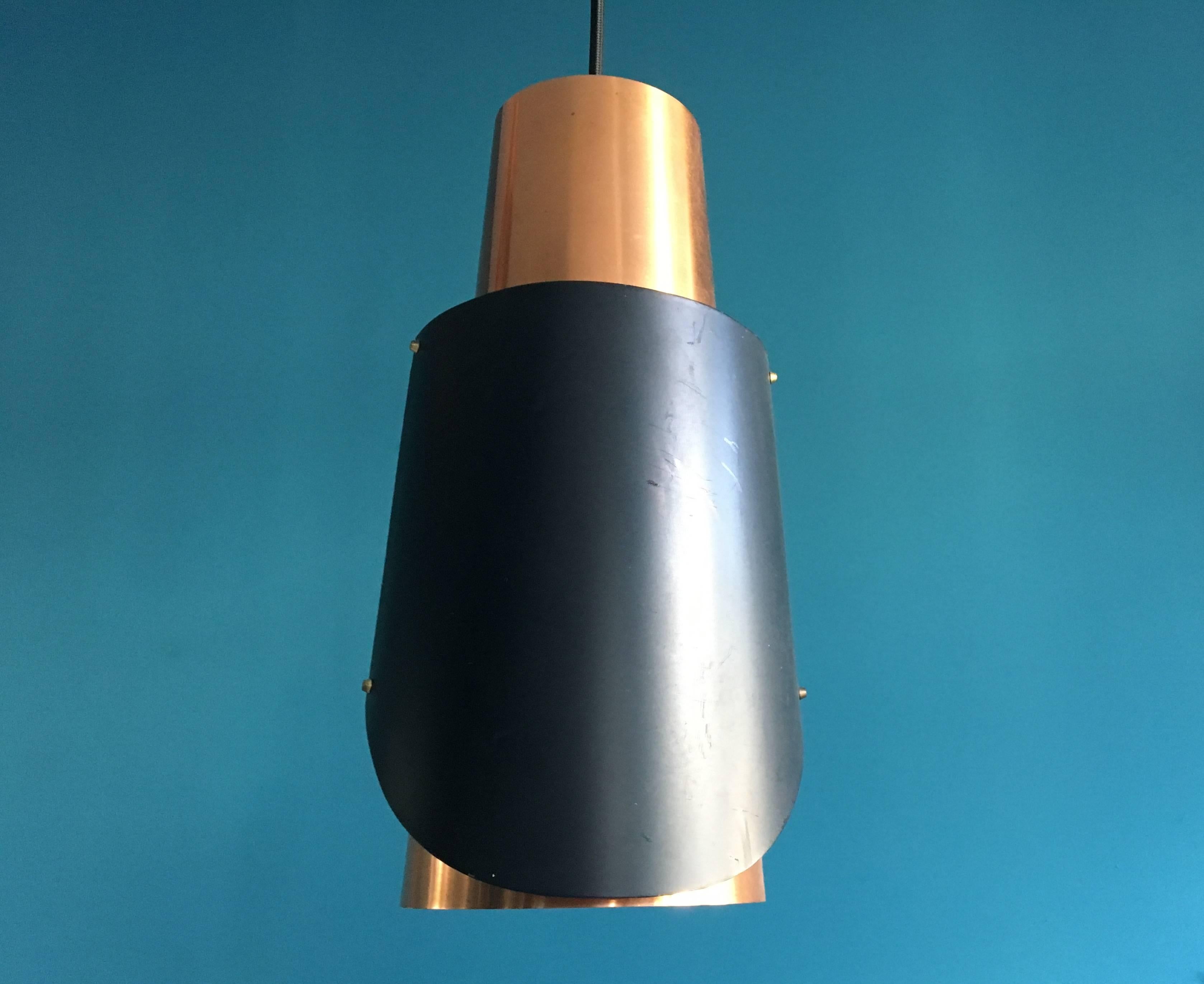 This pair of copper pendant lights was designed by Bent Karlby and produced by Danish company Lyfa in the 1960s. The model is called "Østerport" and is quite rare. The lamp shades are made of thin copper and lacquered metal. The lamps are