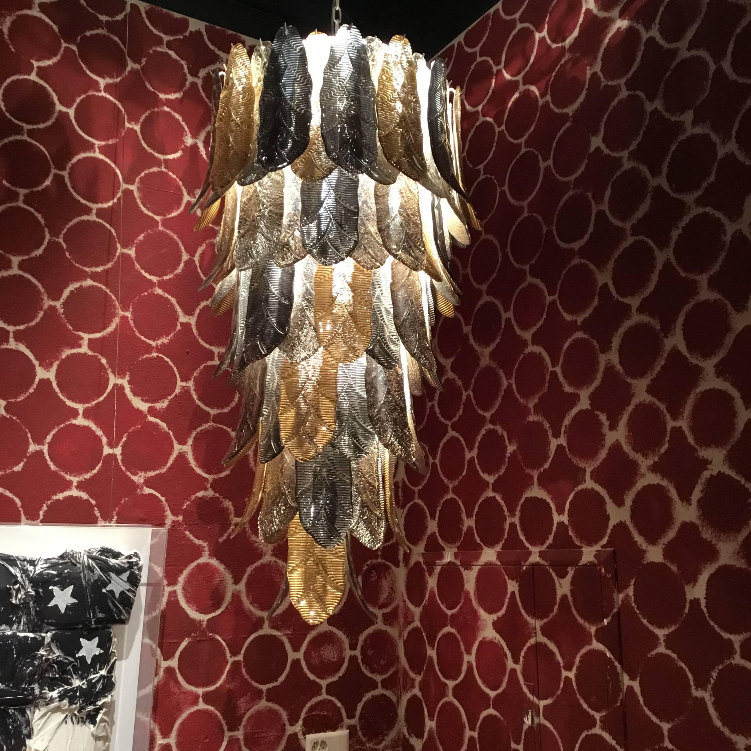 Pièce unique de lustre en verre de Murano, réalisée à la main par un artisan pour sa maison.
Structure en métal et feuilles en verre de Murano de couleur argentée et dorée.
Dimensions : H145xD45cm.