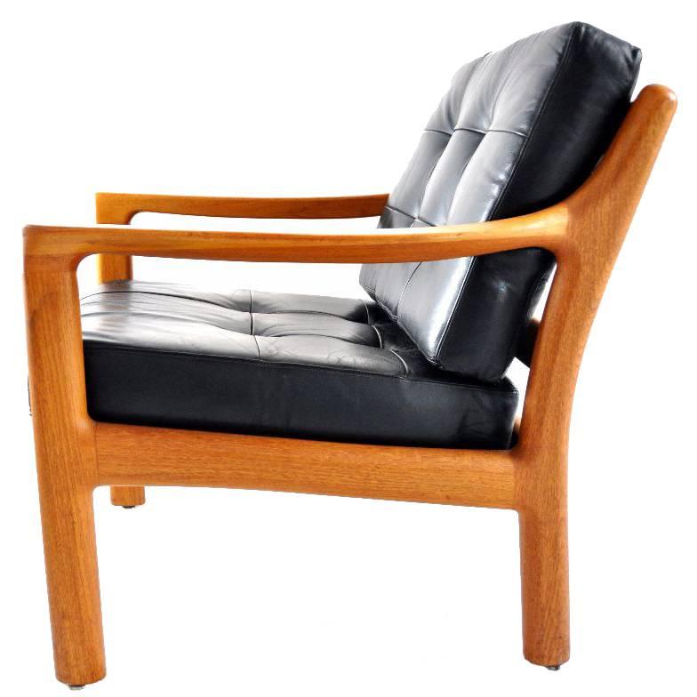 This lounge chair was manufactured by Silkeborg in the 1960s in Denmark. It features a teak frame and is upholstered in black leather.