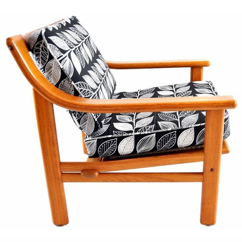 This chair was manufactured in the 1960s by Silkeborg in Denmark. It has a teak frame and is upholstered in a black and white leaf print jacquard fabric.