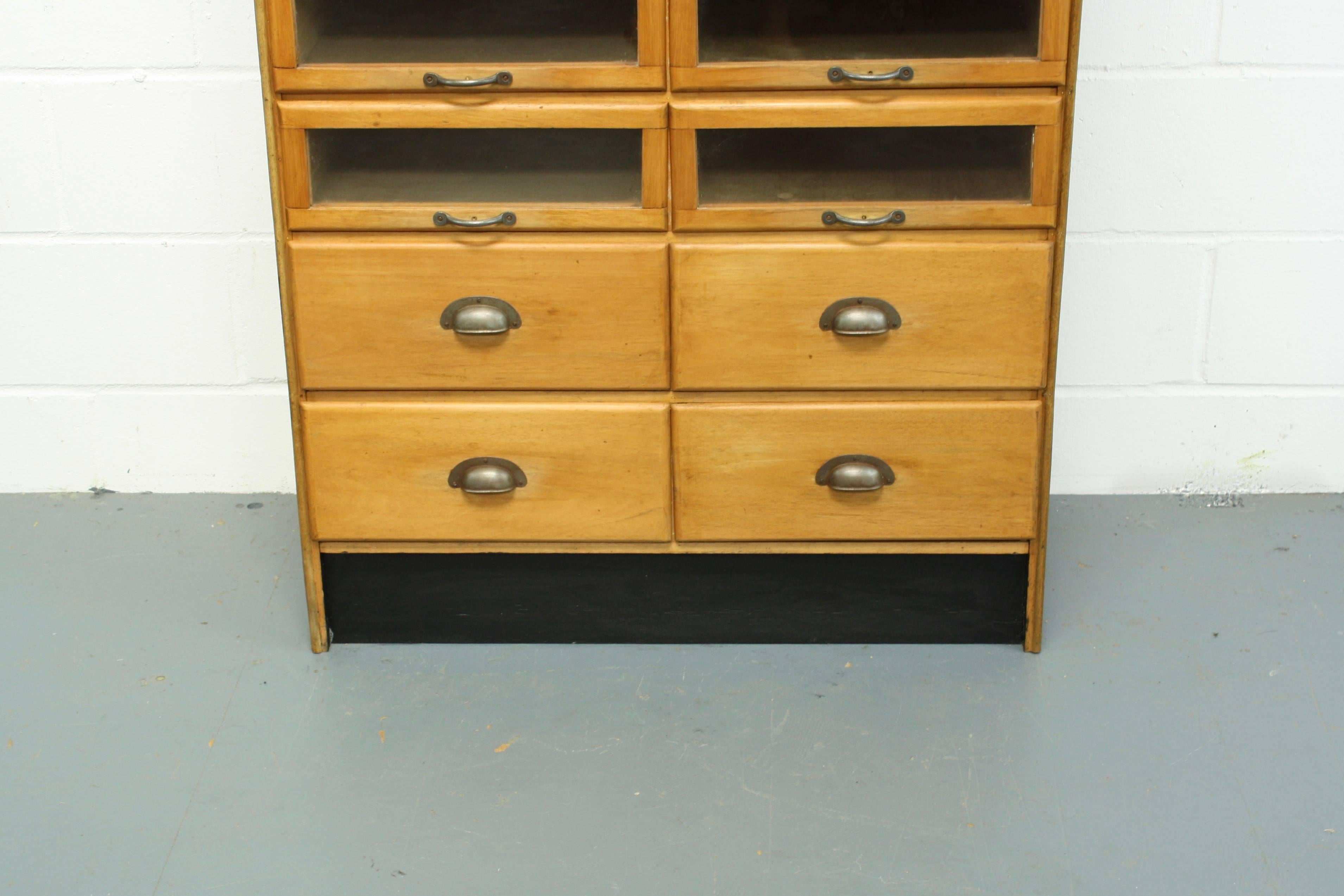 Lovely vintage 20 drawer haberdashery shop cabinet from the early part of the last century.

It has 16 glass fronted drawers and four solid wood base drawers, all with metal handles.

In good vintage condition. Some scuffs here and there,