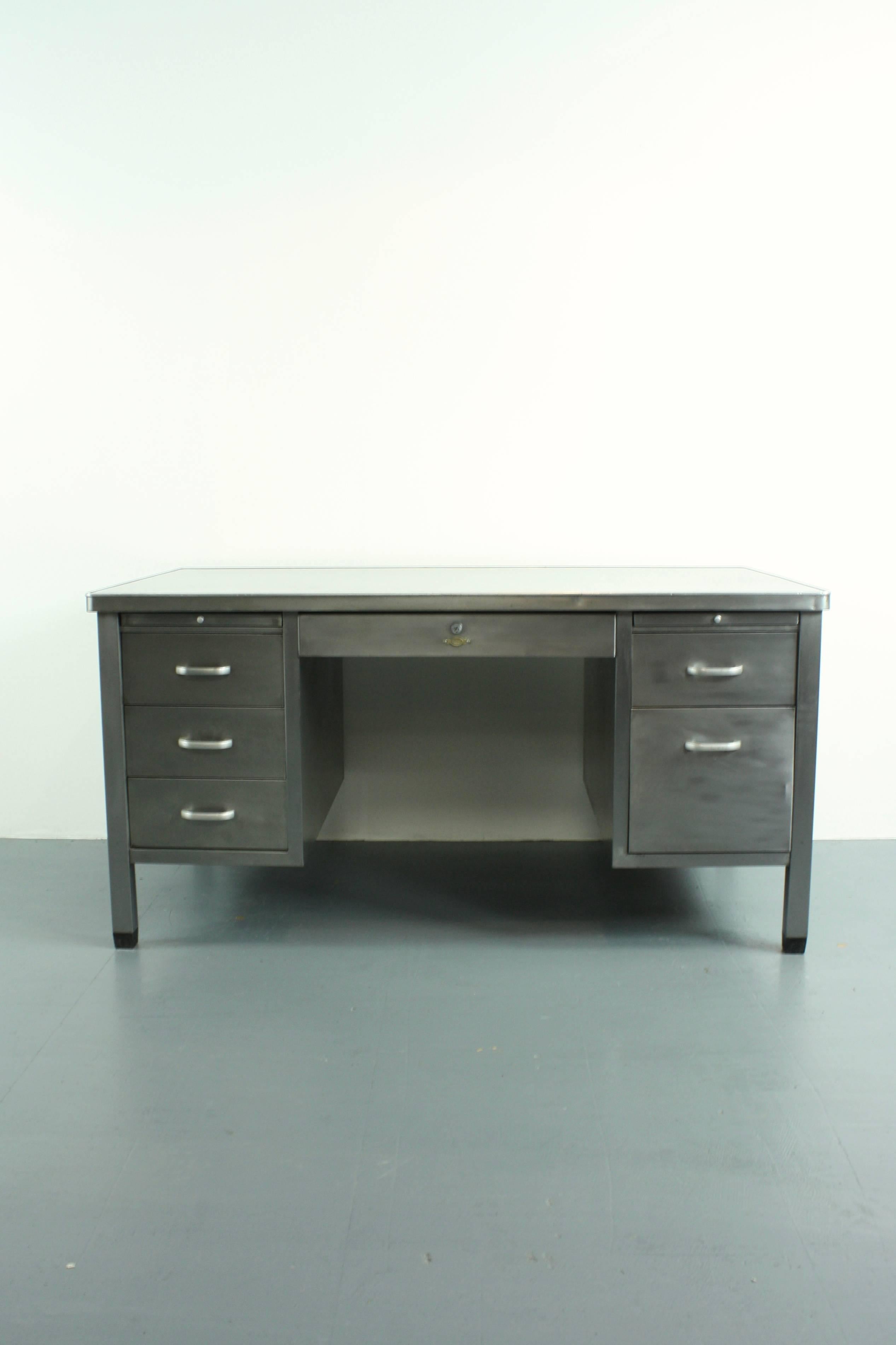 Vintage Midcentury stripped and polished double pedestal steel desk with drawers and sliding shelves, made by Art Metal. 

In good vintage condition - this piece comes from a working Industrial environment and as such, has signs of wear and tear