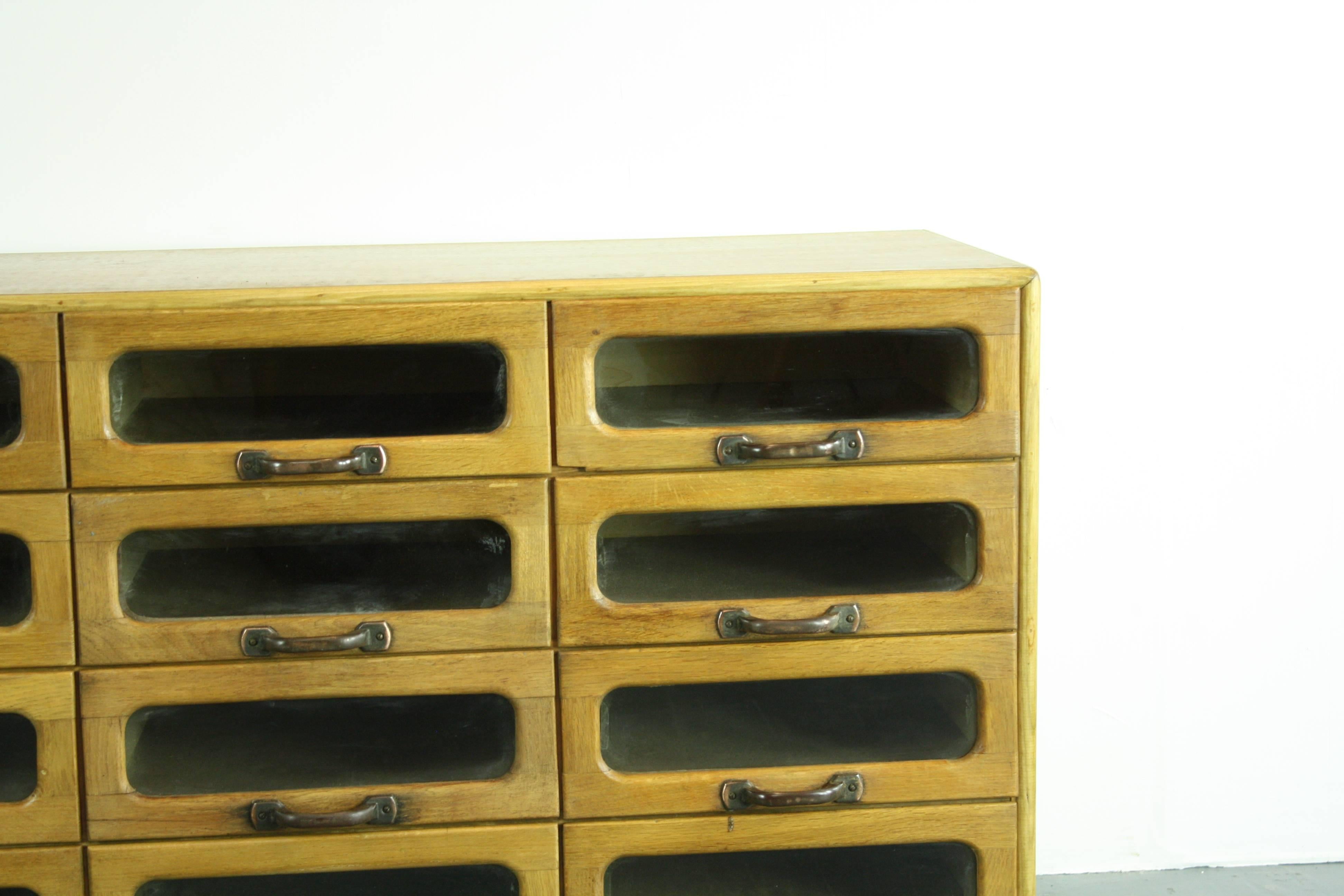 Lovely 12-drawer haberdashery shop cabinet from the first half of the last century. 

It has 12 glass fronted drawers, all with metal D handles.

Overall, in good vintage condition. 

Please bear in mind this has come from a working shop and