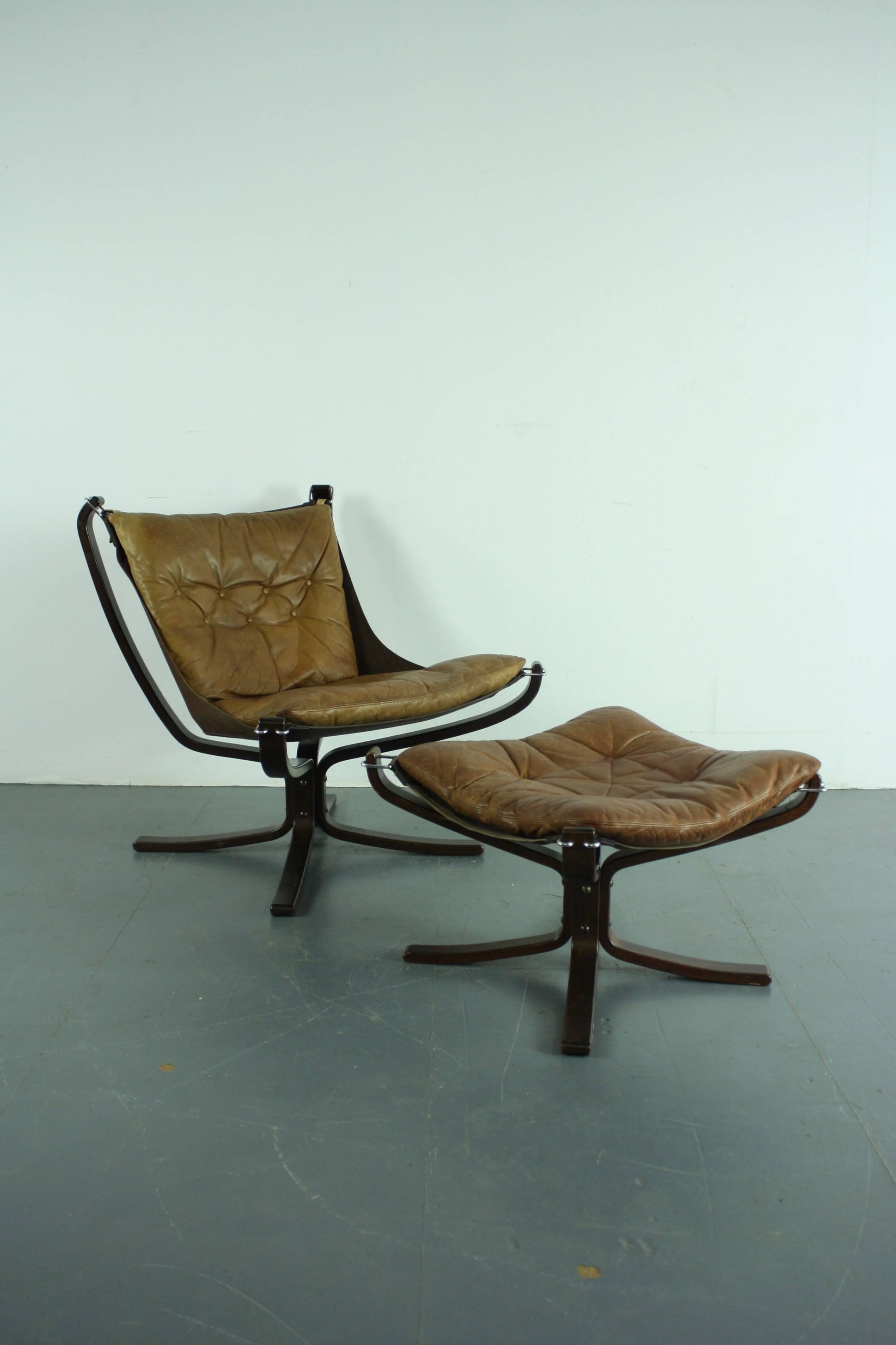 Low back camel brown vintage leather Falcon chair designed by Sigurd Resell with matching ottoman.

In good vintage condition. There is some age-related wear, as expected, but nothing really noticeable, and nothing specific to mention. The leather