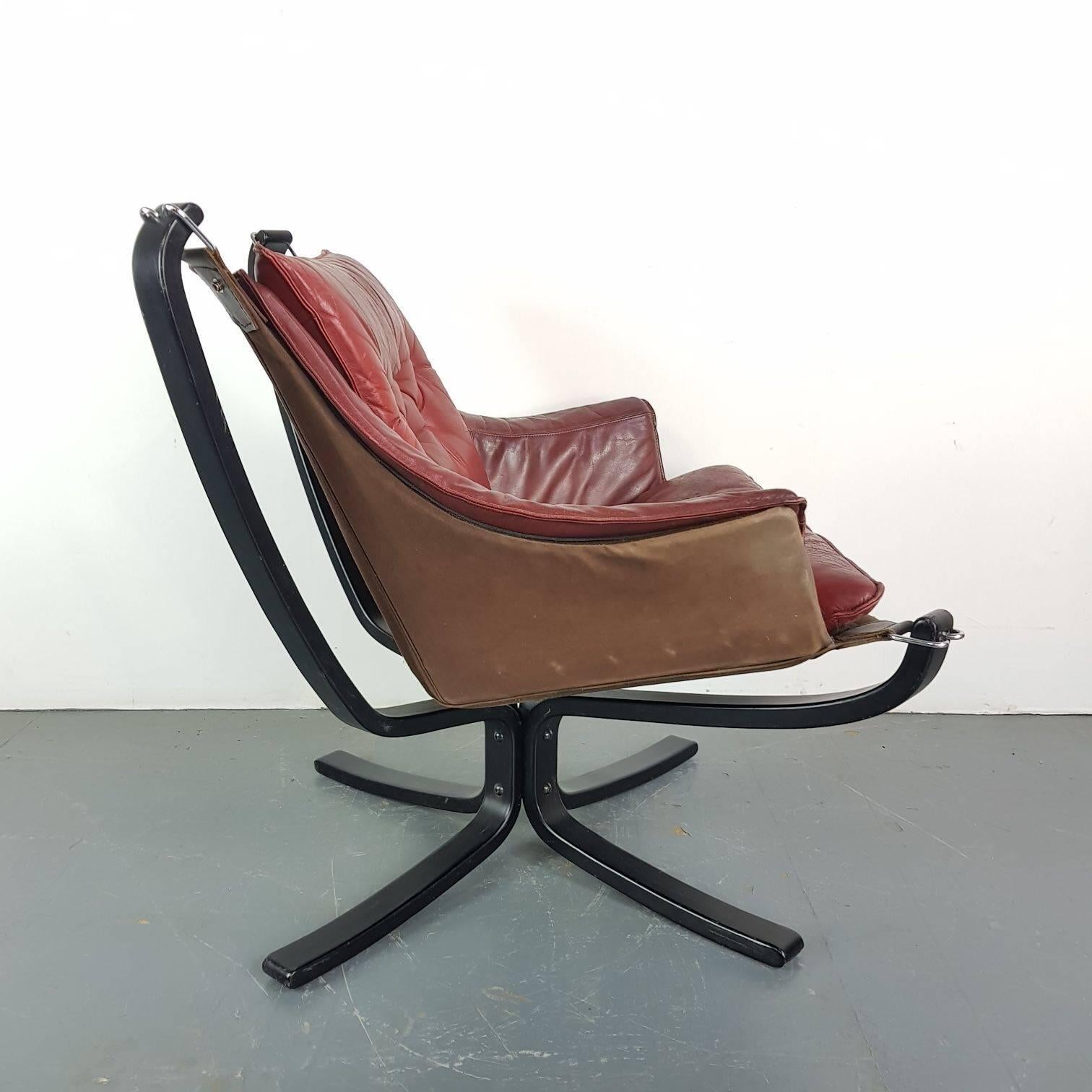 Lovely low back winged chestnut brown leather Falcon chair designed by the Norwegian designer, Sigurd Resell, in the 1970s. With black base which is an X-shape. 

In good vintage condition. The leather is in good condition for its age with no rips