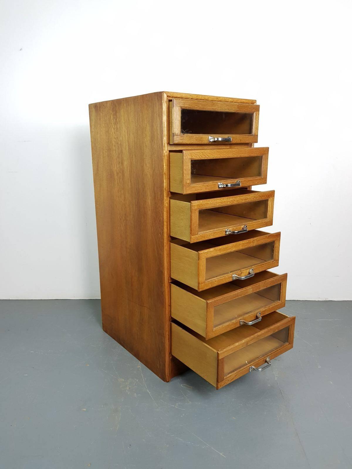 Six-drawer single column haberdashery shop cabinet. 

It has six glass fronted drawers, all with metal D handles.

Approximate dimensions:

Height: 110cm

Width: 47cm

Depth: 58cm

Drawers: 40cm x 44.5cm x 12.5cm.

Overall, in good