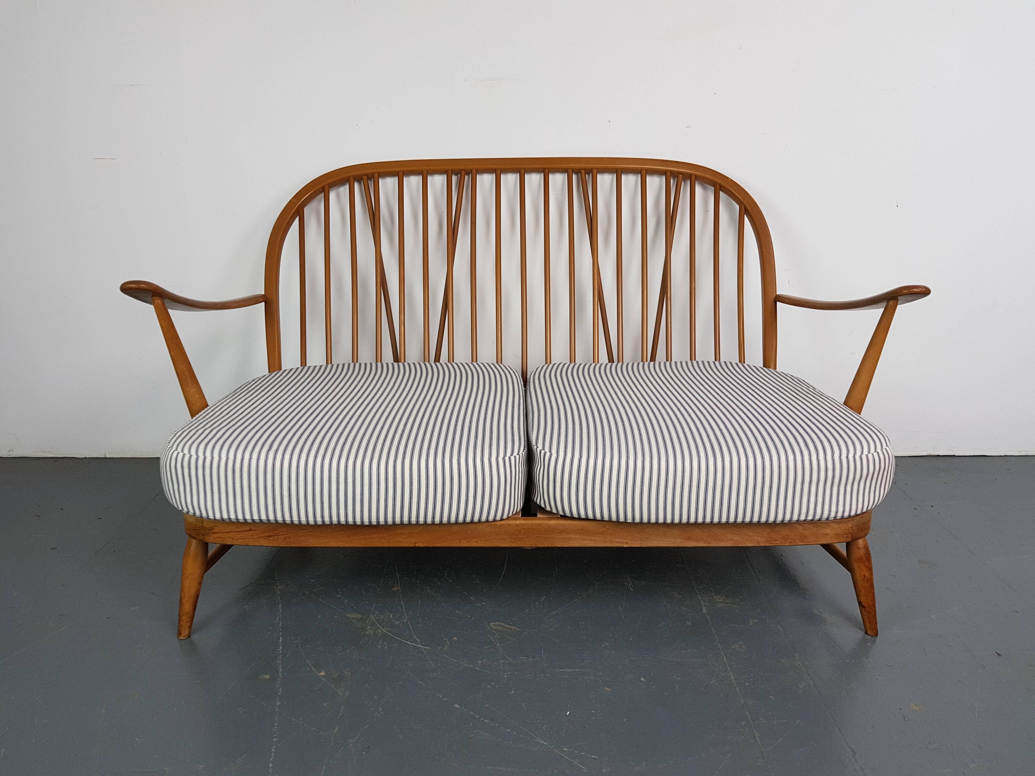 Refurbished blonde Ercol Windsor two-seat sofa.

Newly upholstered in lovely French ticking. 

This piece is in good vintage condition.  The frame is solid and sturdy.  There are a few scuffs, scratches and marks commensurate with age but