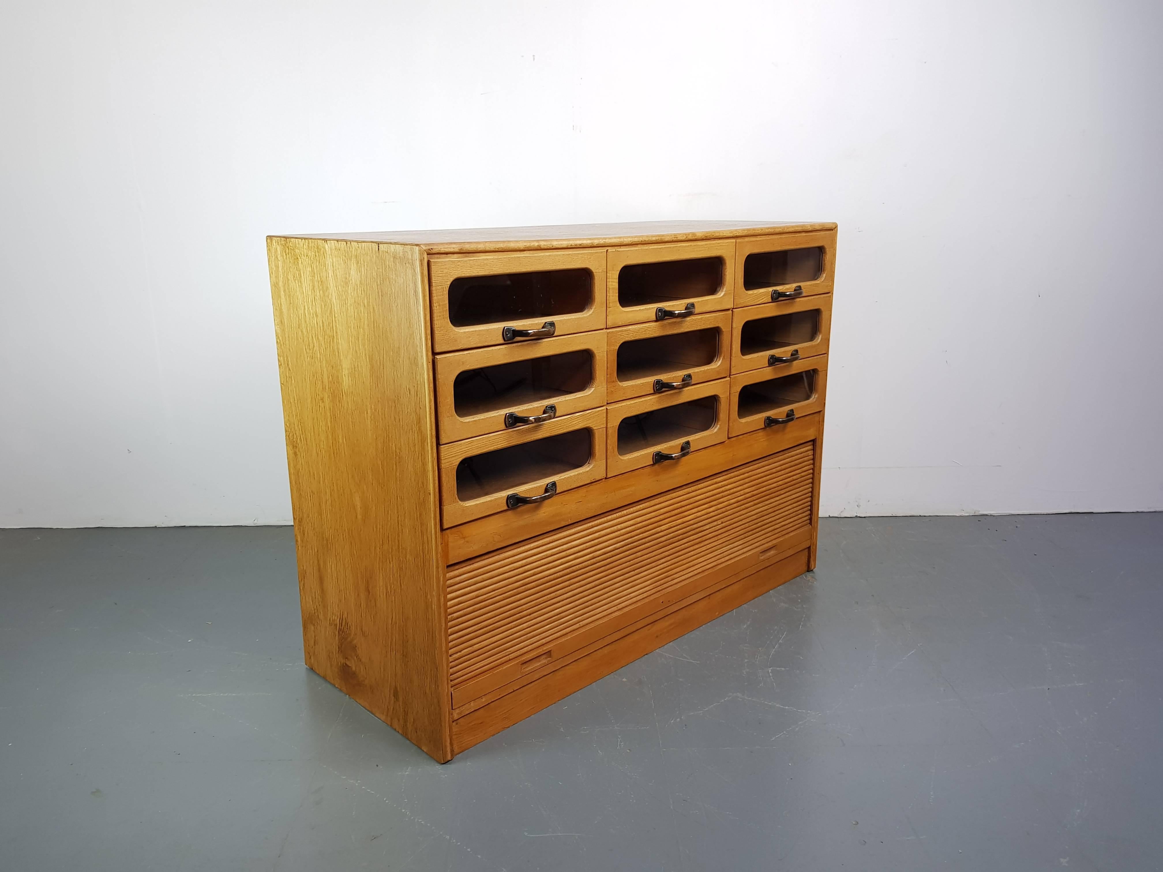 Lovely nine drawer haberdashery shop cabinet from the first half of the last century.

It has nine glass fronted drawers, all with metal “D” handles and a base compartment with roll down front.

Approximate dimensions:

Height 89cm

Width