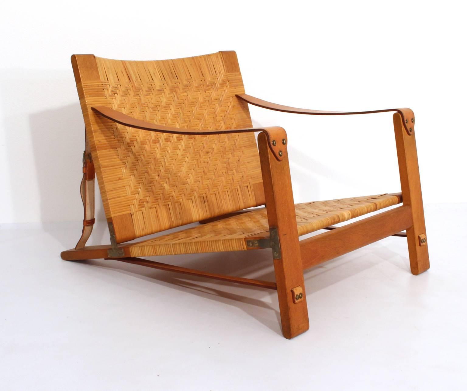 Hunting chair design Børge Mogensen, 1955.
Made by cabinetmaker Erhard Rasmussen, Copenhagen, Denmark.
This rare model were made in oak, cane, leather and brass.

Attached photo from The Copenhagen Cabinetmakers Guild Exhibitions, 1955.
see