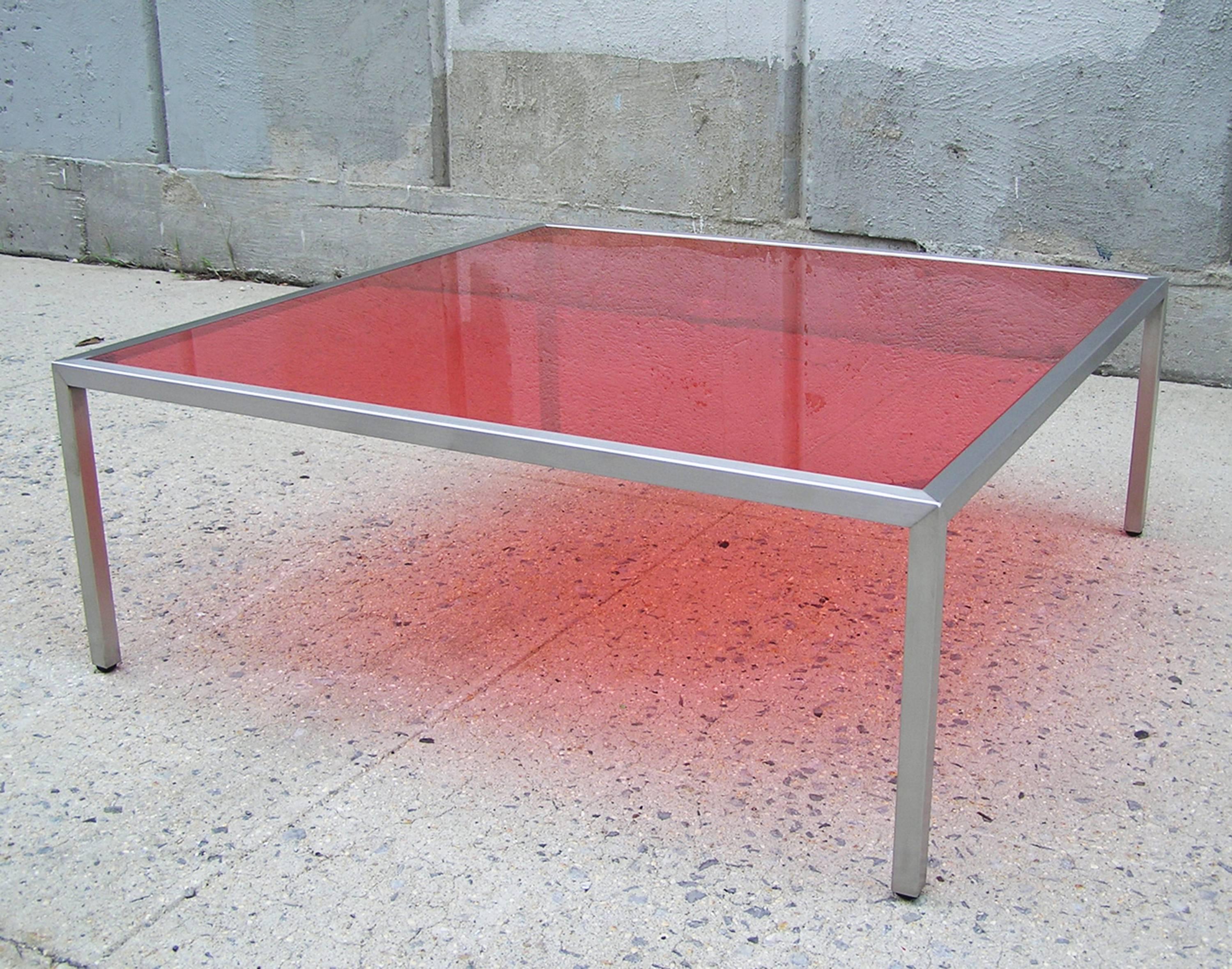 1" square tubular stainless steel frame with linear brushed supports an inset red laminated glass. Other colors or clear glass is available.