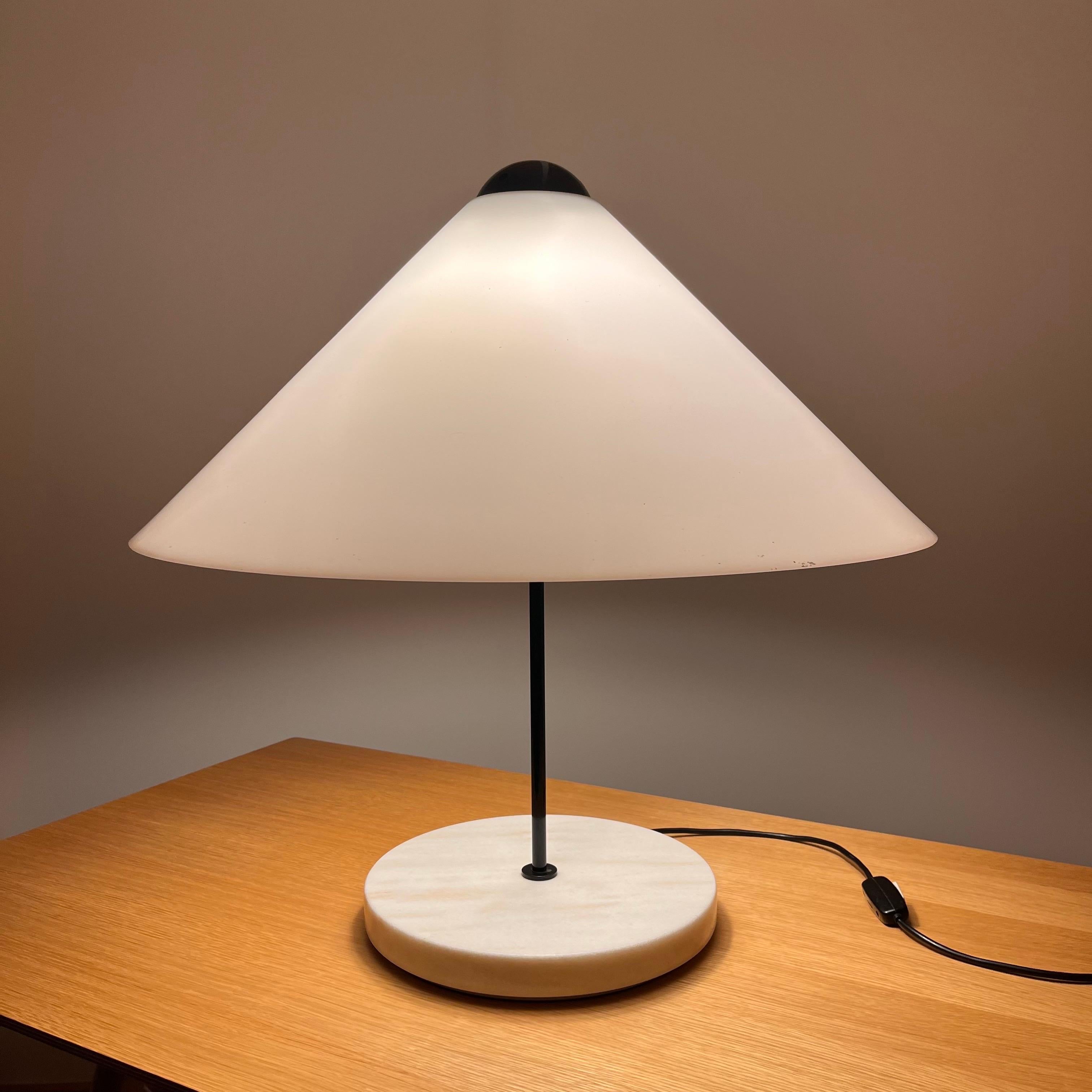 Vico Magistretti (1920-2006)

Snow 201

A metal and methacrylate table lamp, the white methacrylate conical shade resting on a black lacquered metal sphere issuing two light bulbs on a black thin cylindrical stem on a white marble circular