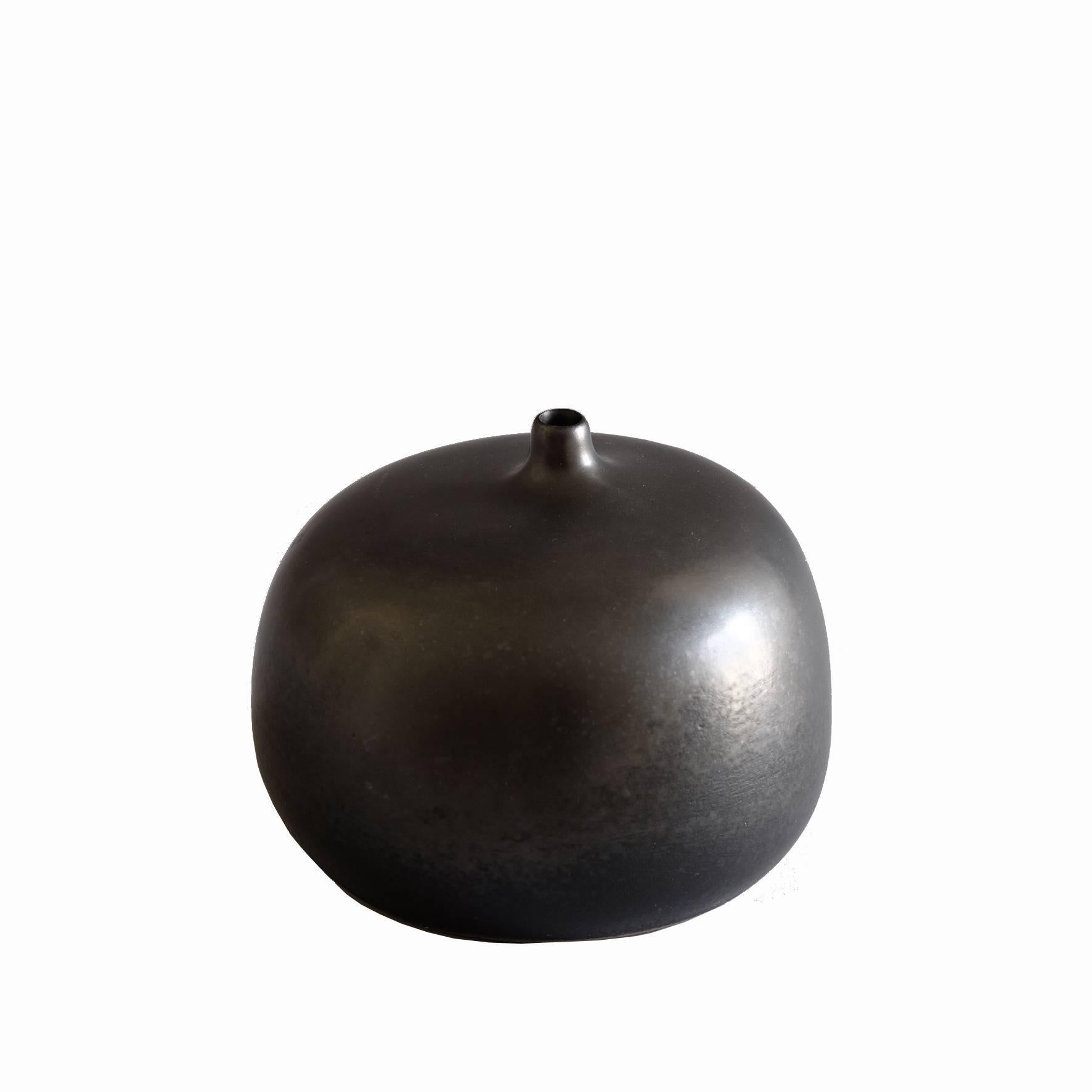 An apple shape ceramic vase with a black cover.
Signed underneath “Jouve” and artist’s cypher “Alpha”.
