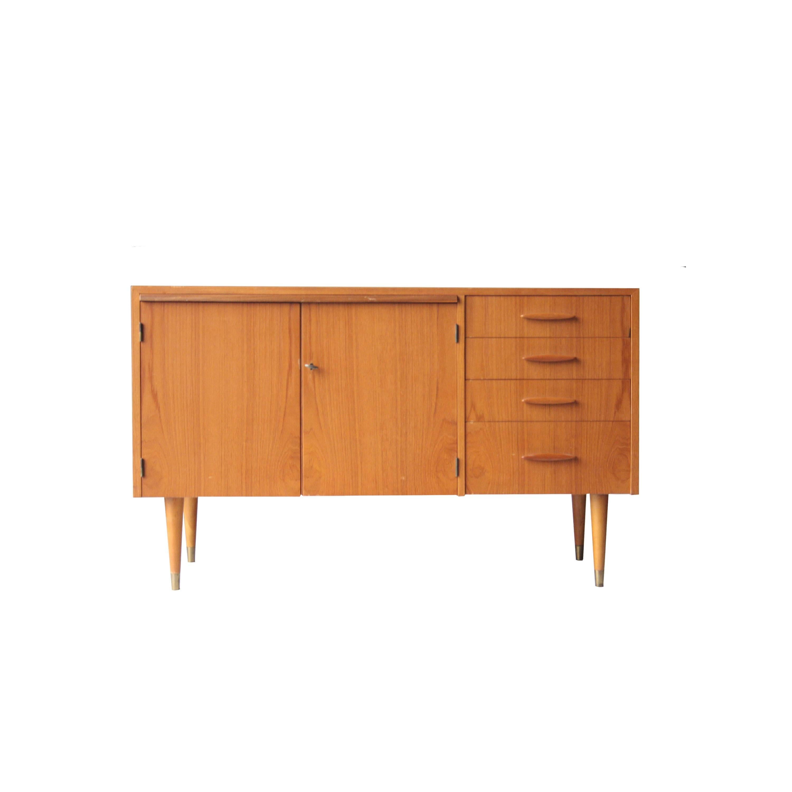 Teak wooden cabinet with doors, drawers and extensible desk. Conic legs with brass finishing.
 