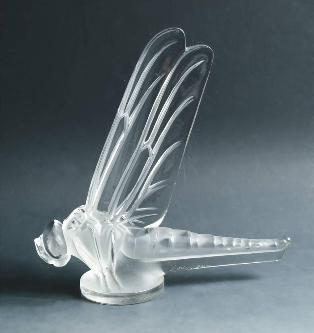 Rene Lalique (1860-1945)
A 'grand Libellule' Mascot, model introduced 1928
no. 1145, clear and frosted glass
8 ¼ in. (21 cm.) high
Molded R. Lalique and engraved R. Lalique France
Measures: Tall 21 cm X long 20 cm. Model created in 1928,