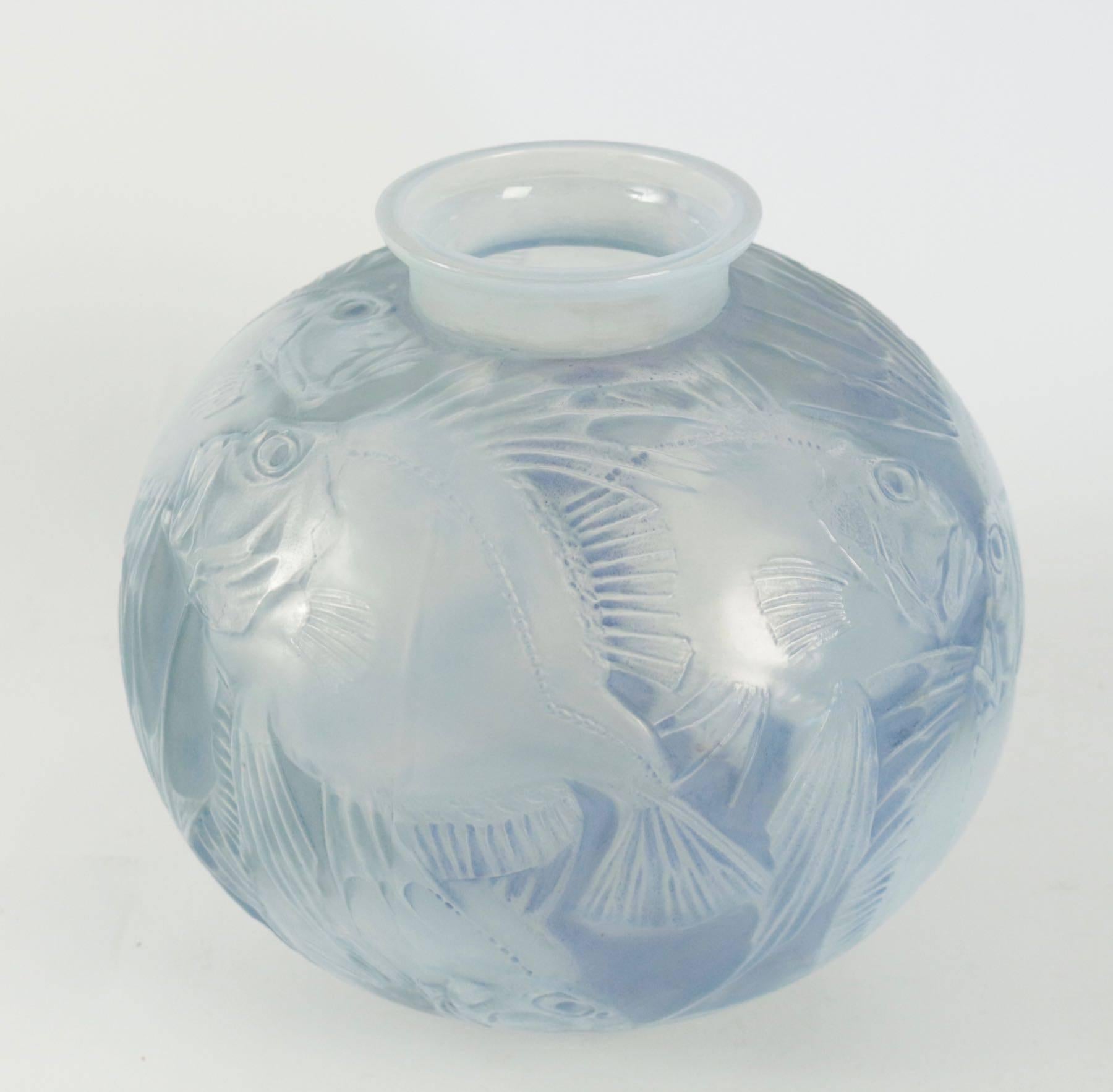 Rene Lalique (1860-1945) vase Poissons created in 1921.
Stopped in 1937.
Measuring 24.5 cm tall opalescent glass and highlighted with blue stain fish decorated glass R. Lalique Vase with both a relief molded signature on the side of the