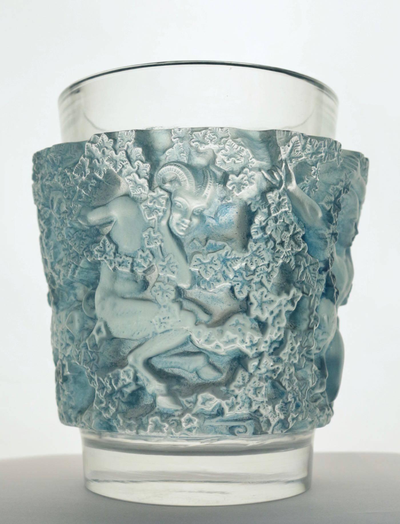'Bacchus' a Lalique clear and frosted glass vase
No. 10-922, designed 1938, signed R. Lalique, France.
Moulded with fauns and trailing ivy, heightened in blue
Measures: 7 in. (18 cm.) high
pan style figural motif.