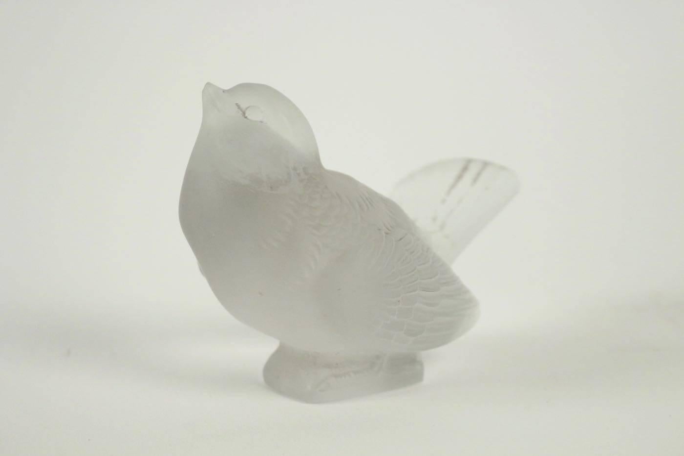 René Lalique Moineau:
8.5 cm tall upward looking frosted glass bird figure R. Lalique paperweight.
Lalique Presse-Papiers Moineau Moqueur: Frosted glass bird figure with the beak and tail both pointing up and the wings tucked down R. Lalique
