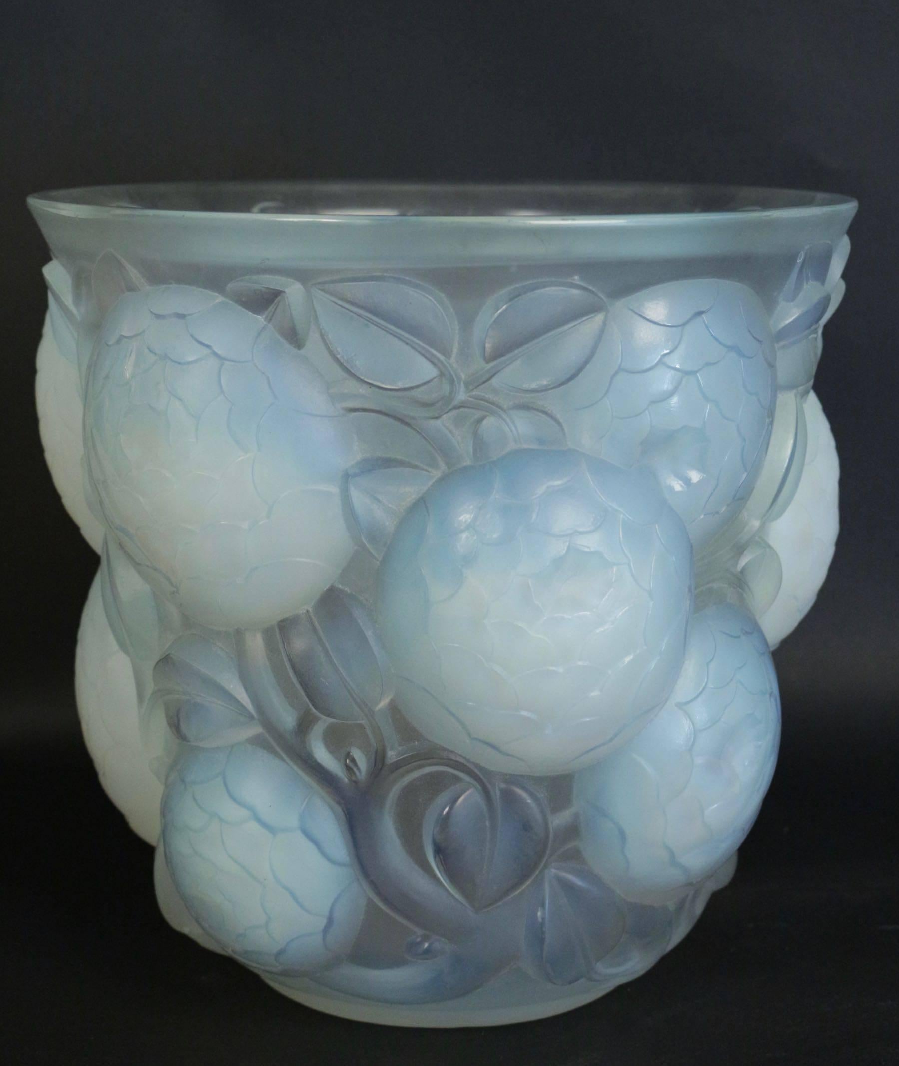 Rene Lalique Oran opalescent vase.
Model: 999, circa 1927.
Measures: Lalique vase Oran: 26.5 cm tall by 27 cm wide at the top rim frosted heavy press molded high relief large flower heads against a small leafy background R. Lalique Vase.