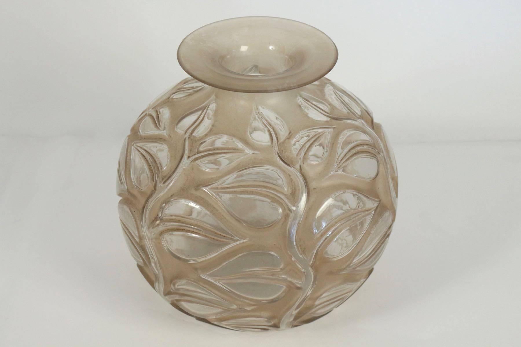 Lalique vase sophora.
 26 cm tall frosted glass decorated with large leaves on recessed thick stems under a flat and widening rim.
Sophora, model created in 1926, non repris après 1947.
Signed cachet R. Lalique France sous la base.
Hauteur: 26