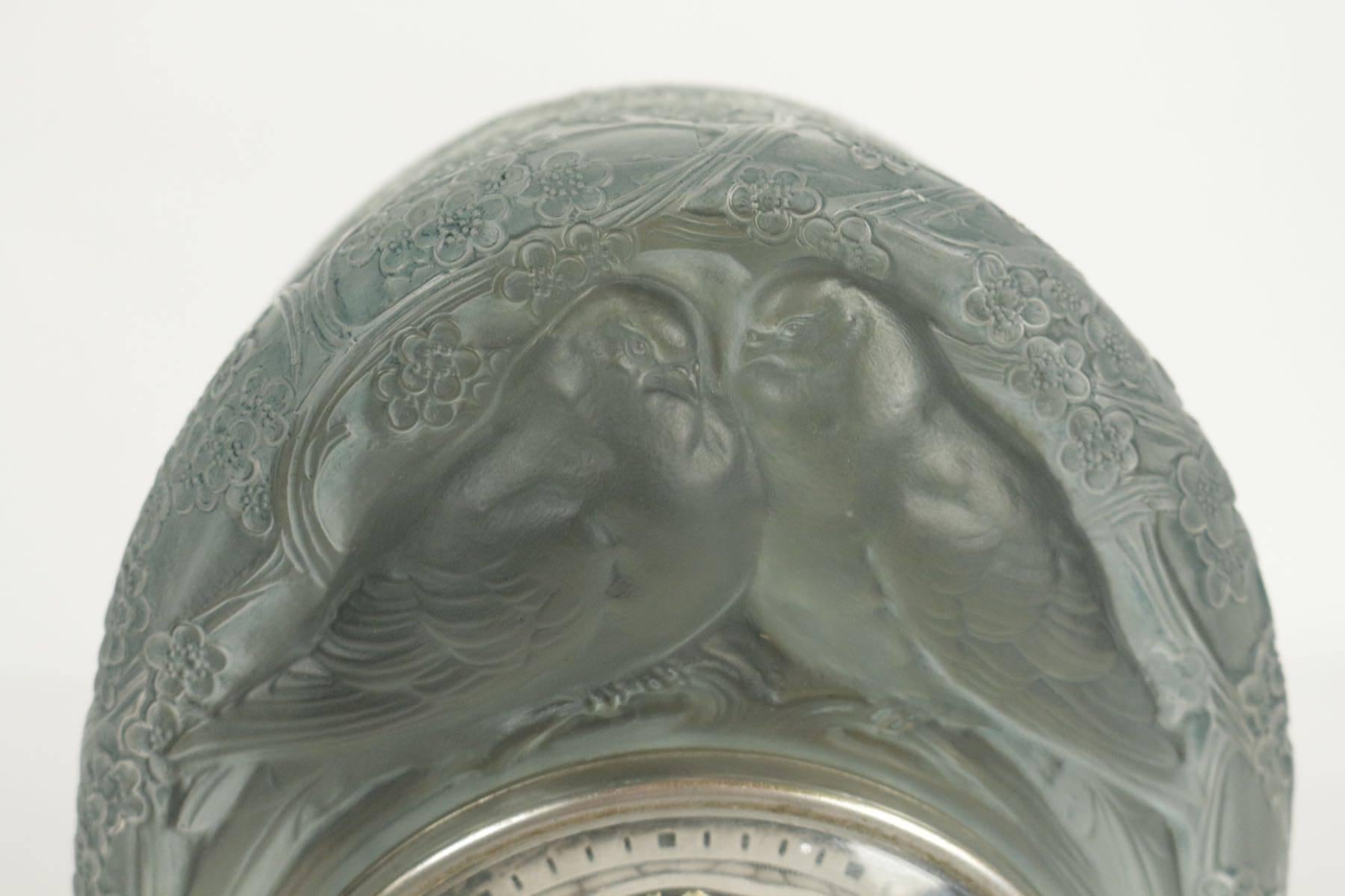 Deux colombes, a moulded-pressed satiny glass mile-stone clock with a Maison ATO milestone dial and new battery.
Two perched birds on branches and foilage motif under a dome shaped.
Signed R.Lalique France.
Model created in 1926.
Measures: H: 8