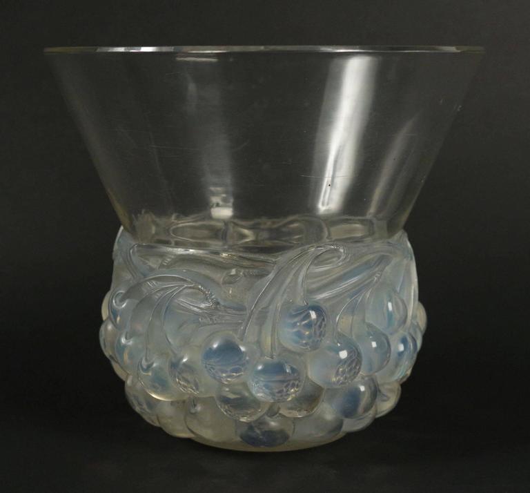 Cerises vase 
 Press-molded glass with an opalescent cherries motif bottom under a flaring undecorated.
20 centimeters tall by over 21 centimeters wide at the widening top rim.
8 inch tall.
Created 18 septembre 1930, signed R. Lalique