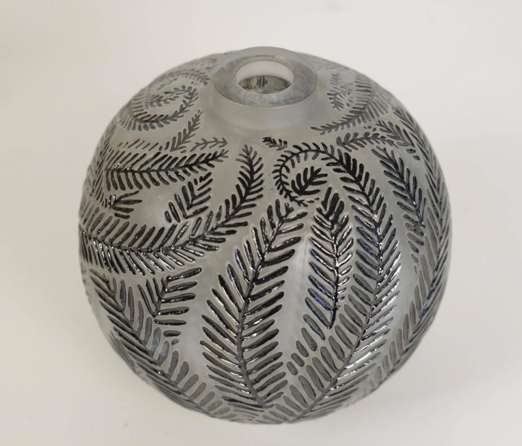 Pressed molded vase frosted and black enemaled.
Palm leaf decorated black enemaled on frosted ground.
Art glass vase of globe form covered with all-over palm leaf motif under small rim surrounding round opening at top.
Signed on bottom 