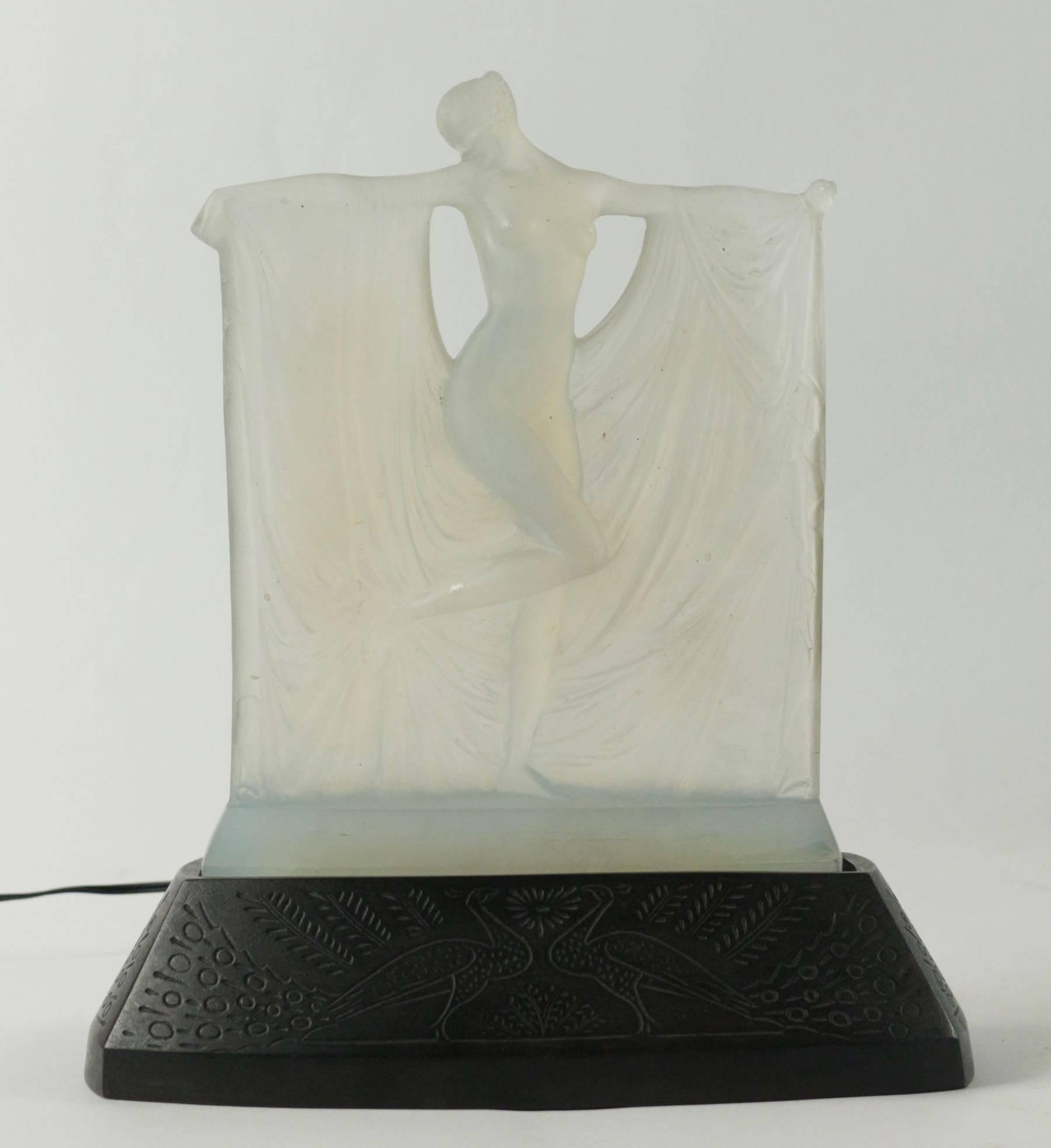R. Lalique
Opalescent glass statuette, by René Lalique, moulded as a maiden amidst drapery held by her outstretched arms, signature to rear of the figure above base, moulded in relief, R.Lalique.
Hand has been glued see picture. We can see a fine