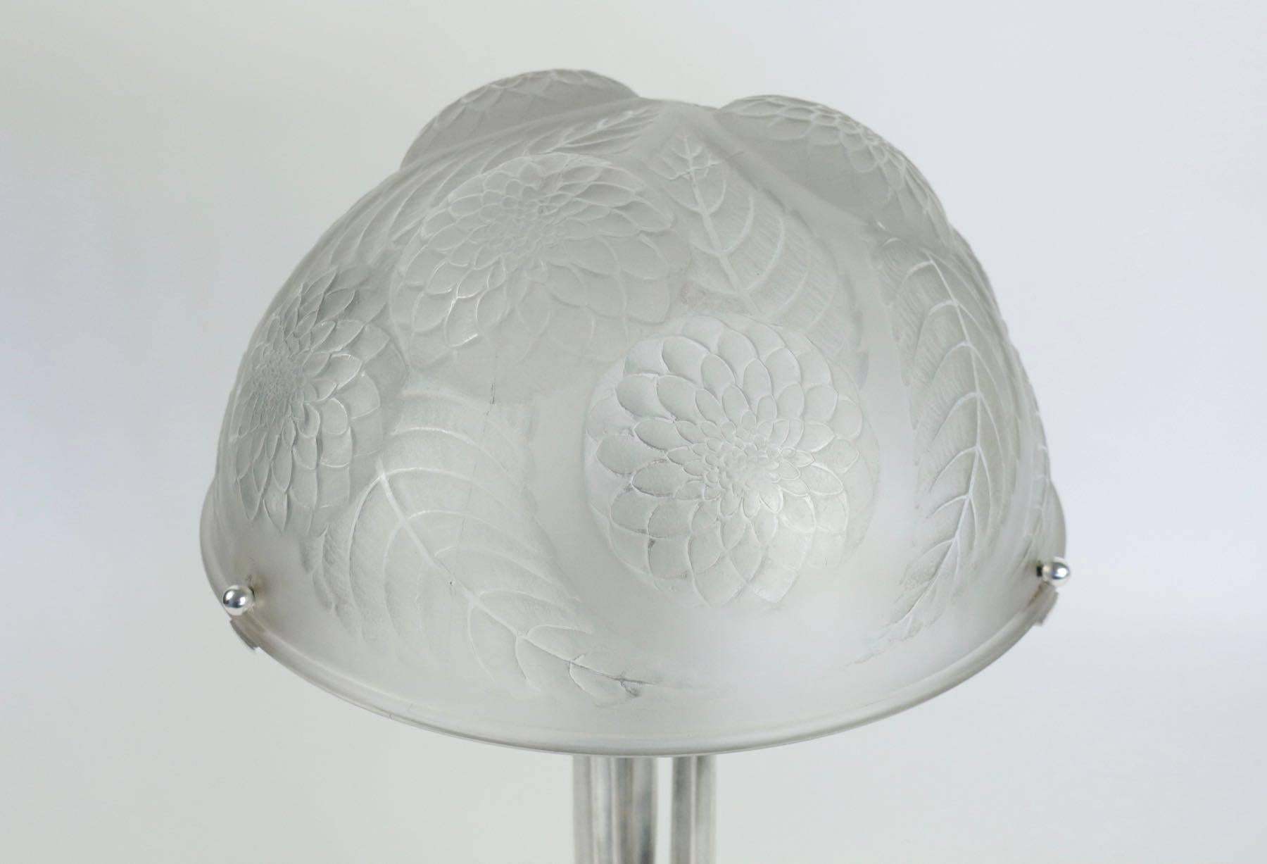 1921, René Lalique Art Deco table lamp with signed, molded glass shade, on an architecturally inspired polished silver plated finish over bronze. 
Measures: 30 cm wide, 
total high 48 cm tall.
 Bronze base 32 cm, diameter 32 cm.
René Lalique