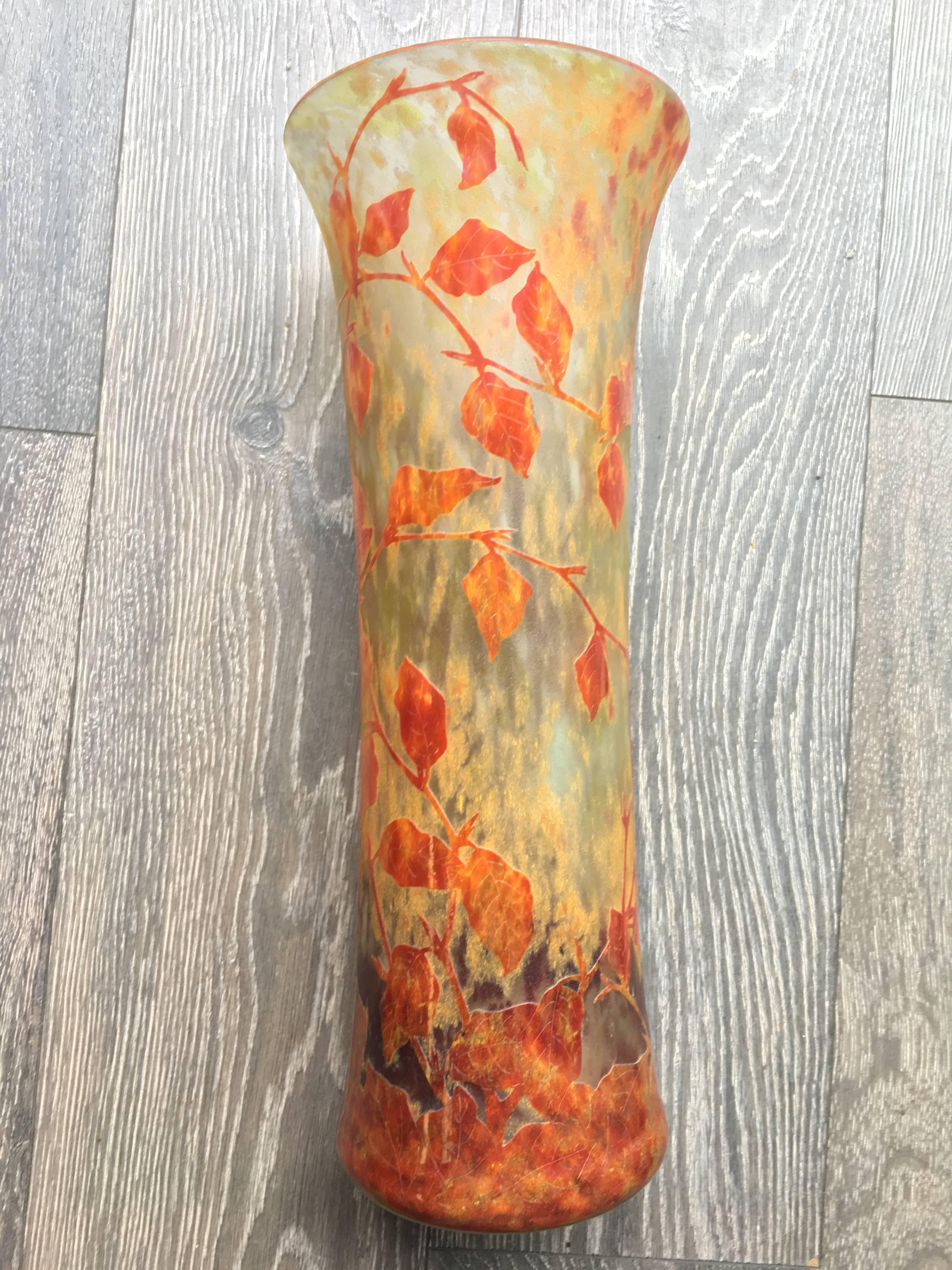 A monumental flattened diabolo shaped vase in lined glass acid-etched a . Signed ‘Daum Nancy’. . Vase in multi-layered glass, decorated with autumn foliage red and brown on marbled yellow background and sandblasted.
The body decorated in autumnal