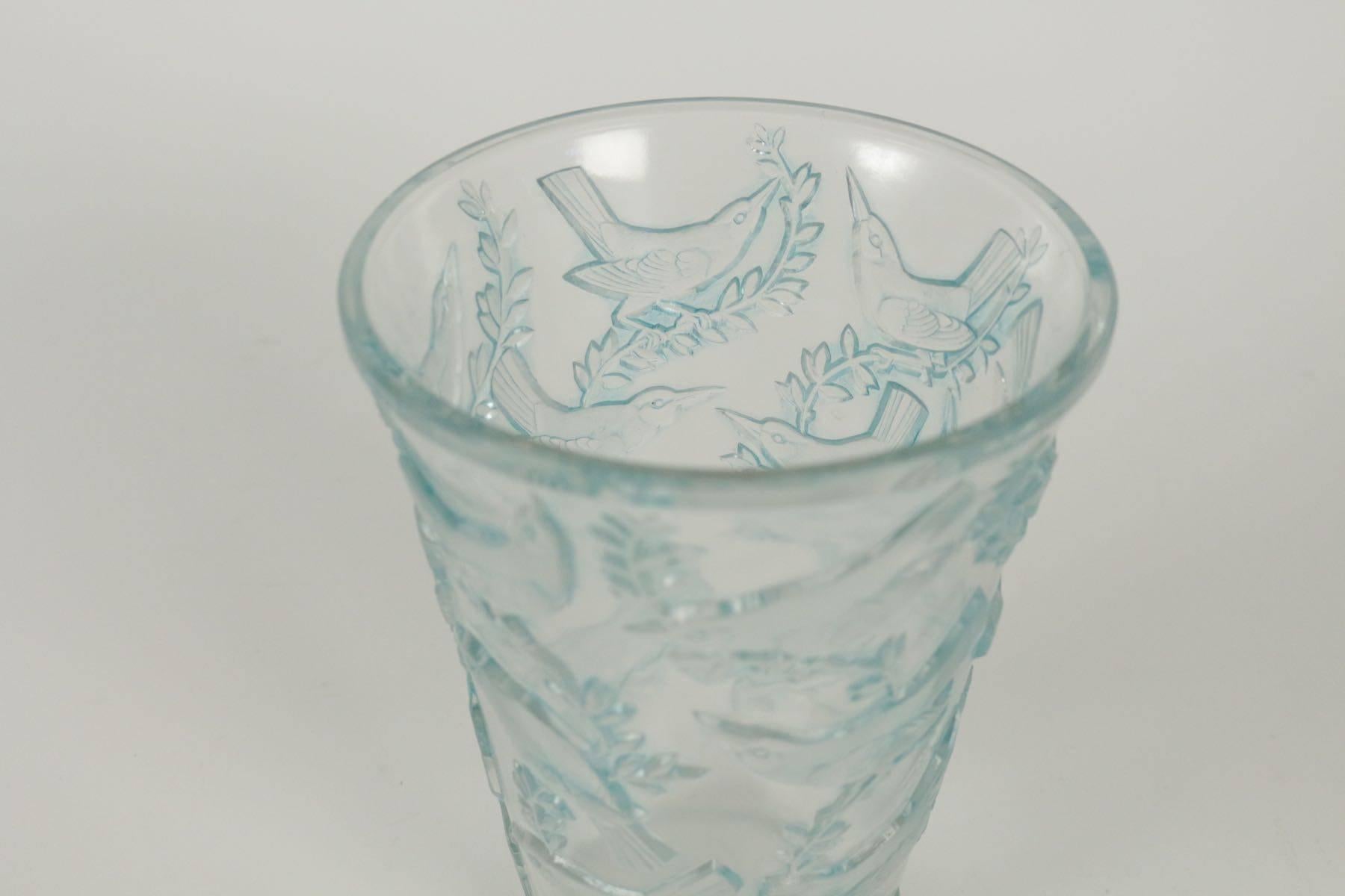 Clear pressed moulded glass vase and blue stained with frosted birds on branches all-around the exterior on the widening to rim form. This vase is impressed with birds resting upon branches vertically climbing the vase. The nicely detailed birds and