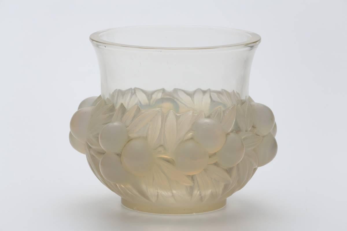 Opalescent molded pressed glass design high relief prunes amongst leaves;
with flaring undecorated upper section over a high relief prunes motif lower area
model designed in 1937
Bibliographie:
Félix Marcilhac, 