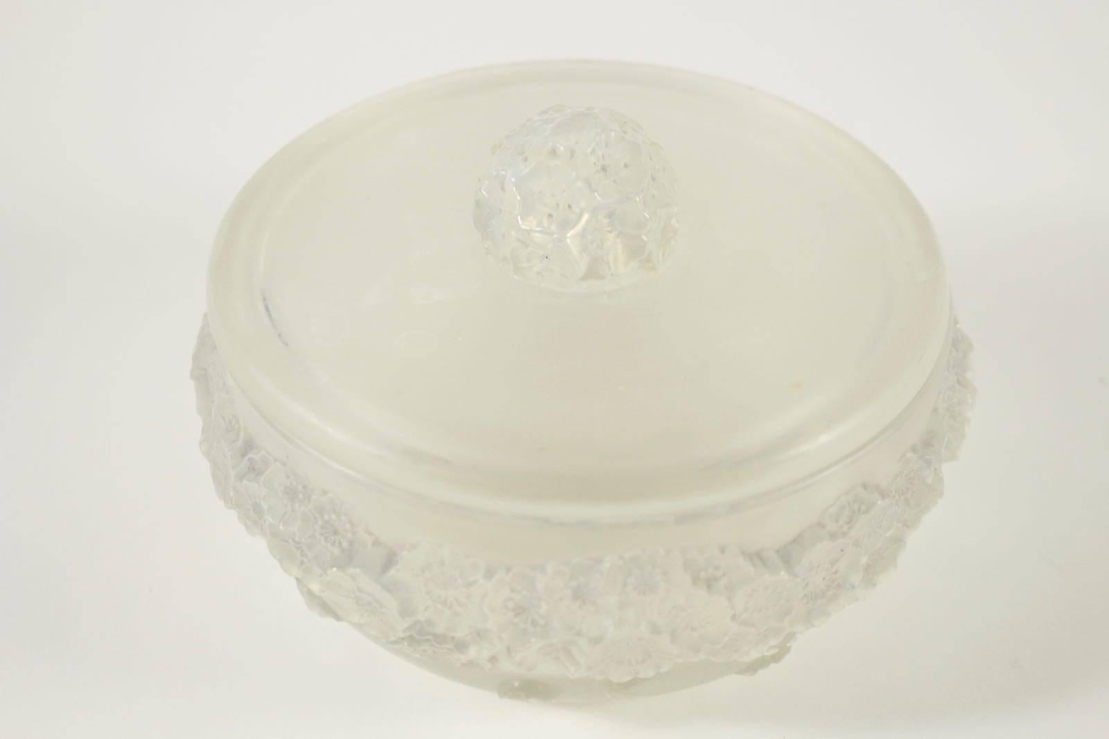 René Lalique
'Primevères' a box and cover,
heavy round high relief floral decoration with flat cover and matching floral handle
Round box 