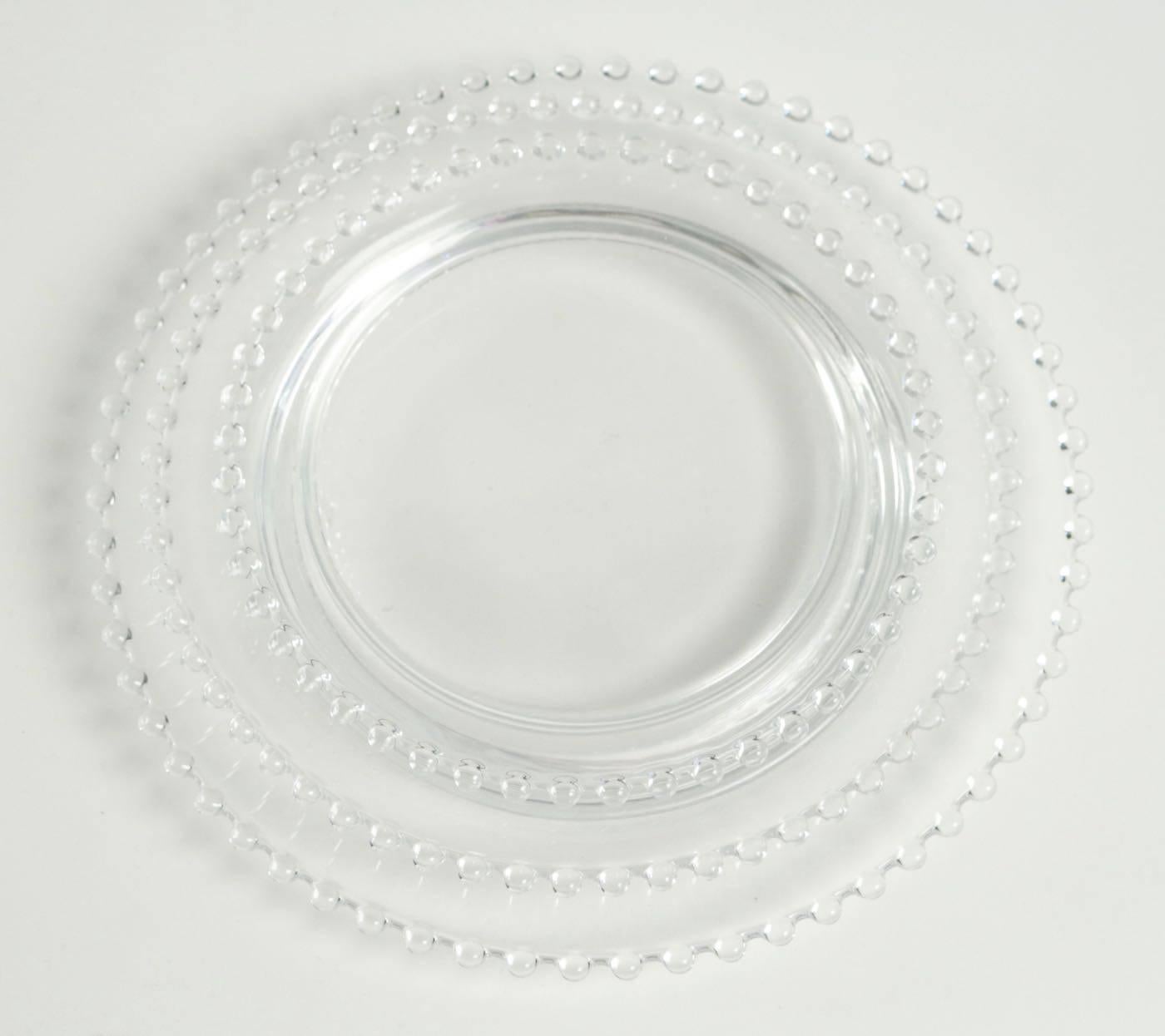 Rene Lalique a set of 38 clear glass round with high relief pearl type bead decorations molded all around the exterior rim 
13 larges plates: 30 cm 
11 plates: 25 cm
15 lunch plates: 21 cm
 Clear incorporating molded small beads all around the