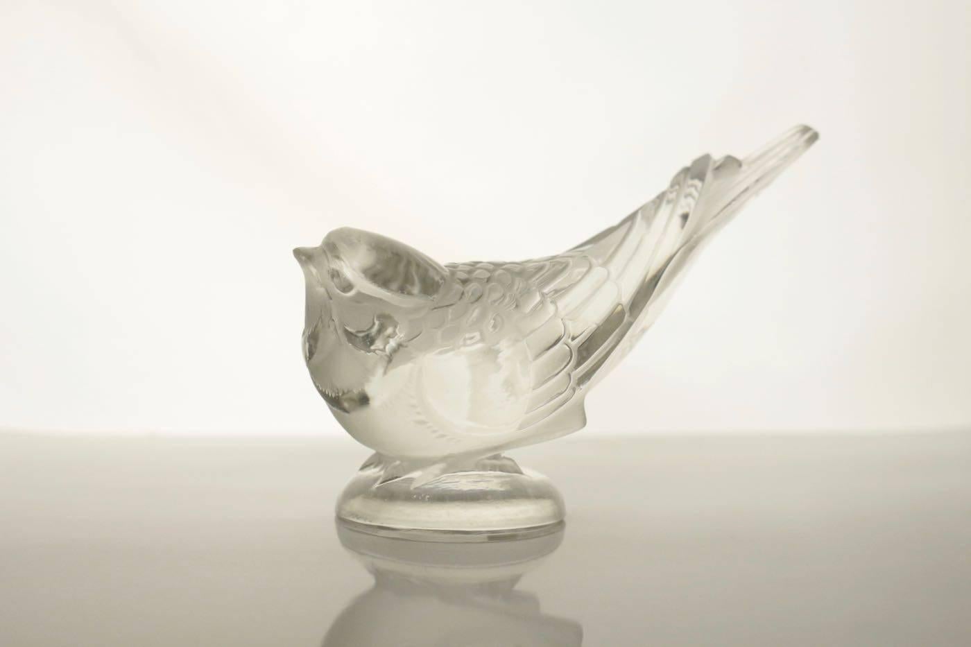 Frosted and clear glass bird figure on incorporated dome shaped round base R. Lalique Paperweight.
Signed R Lalique
model 1209 created in 1931
Marcilhac reference.