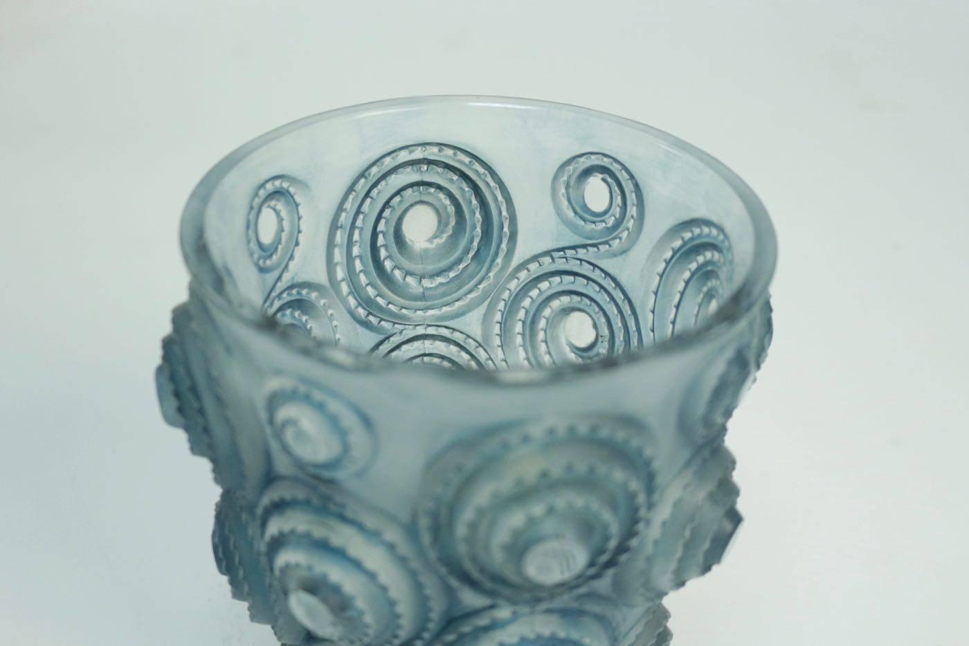 René Lalique (1860-1945) 
Spirales, model created le 25 September 1930
Pressed molded glass highlighted with blue stain.
Signed R Lalique under the base.
Vase. Épreuve en verre moulé-pressé et, en partie, satiné et patiné bleu (Réf. Marcilhac