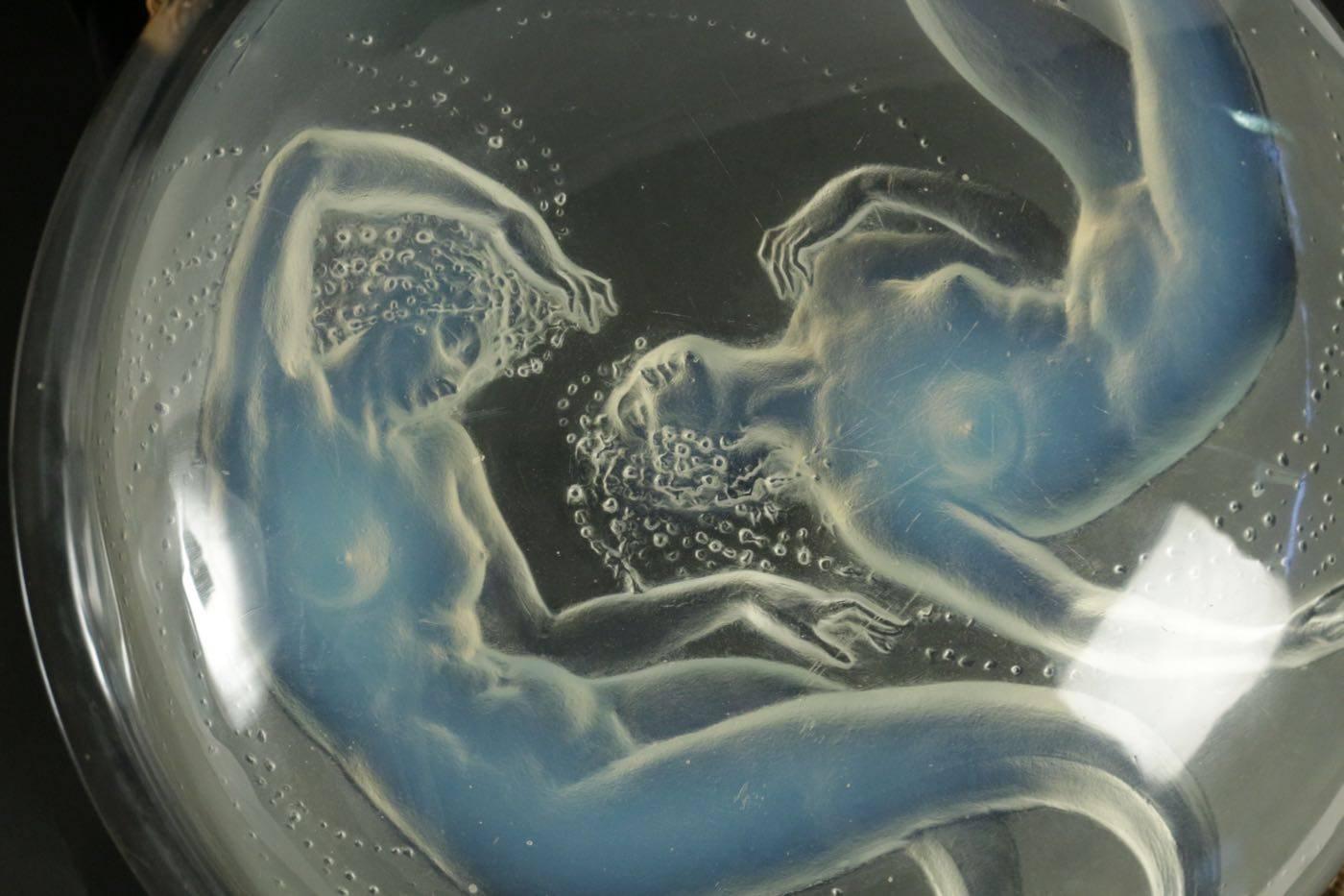 Rene Lalique light fixture Deux Sirenes
39 centimetres wide round opalescent glass bowl form featuring two mythical alluring female type siren figures Lalique light fixture suspended from four cords creating opalescent bowl form glass with four
