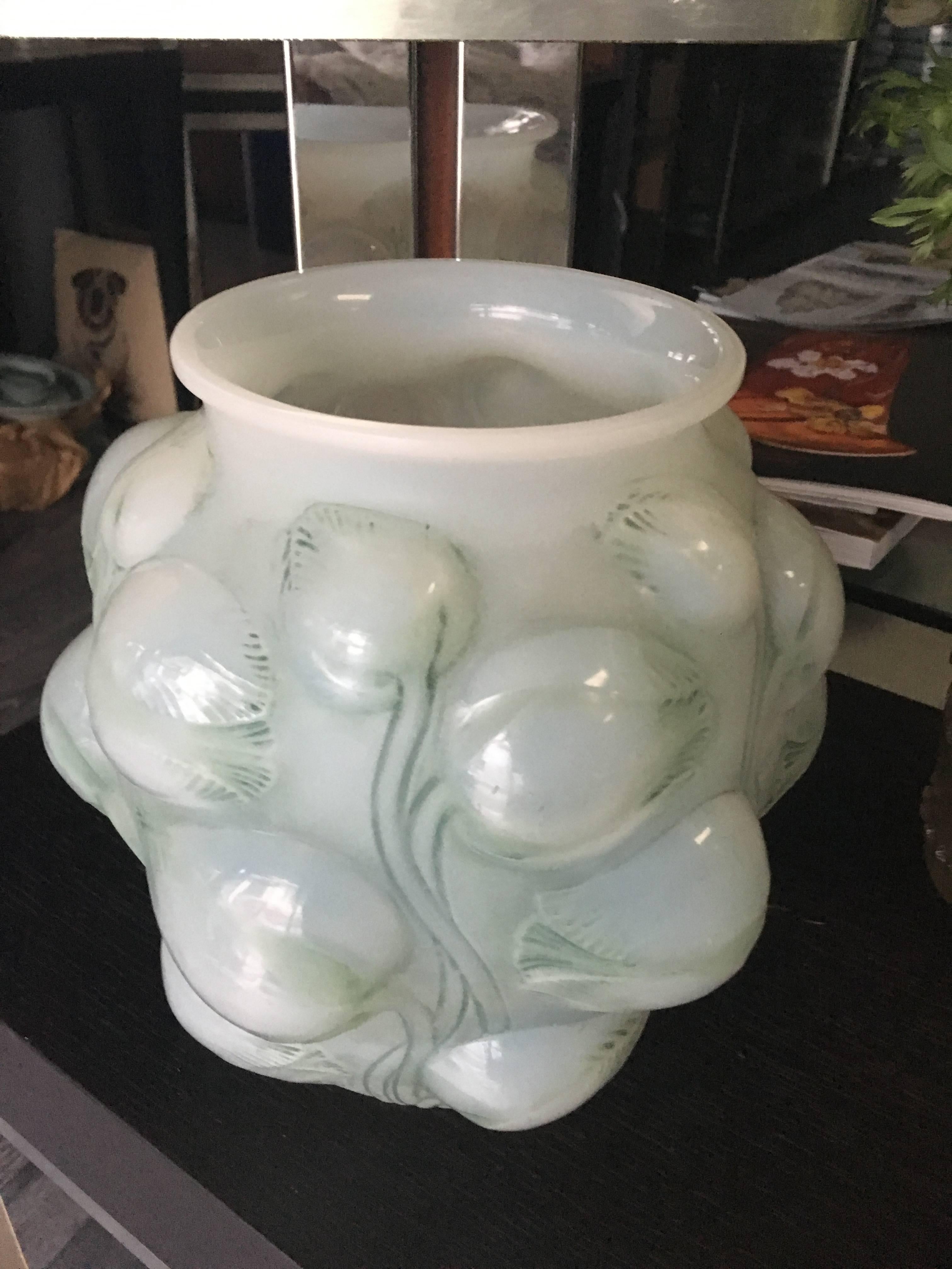 White opalescent roughly mold blown glass with a design of high relief blue or green patinated tulips molded all around the exterior.
 
 Bibliographie: Fe´lix Marcilhac, Rene´ Lalique - Catalogue raisonne´ de l'oeuvre de verre, Les E´ditions de