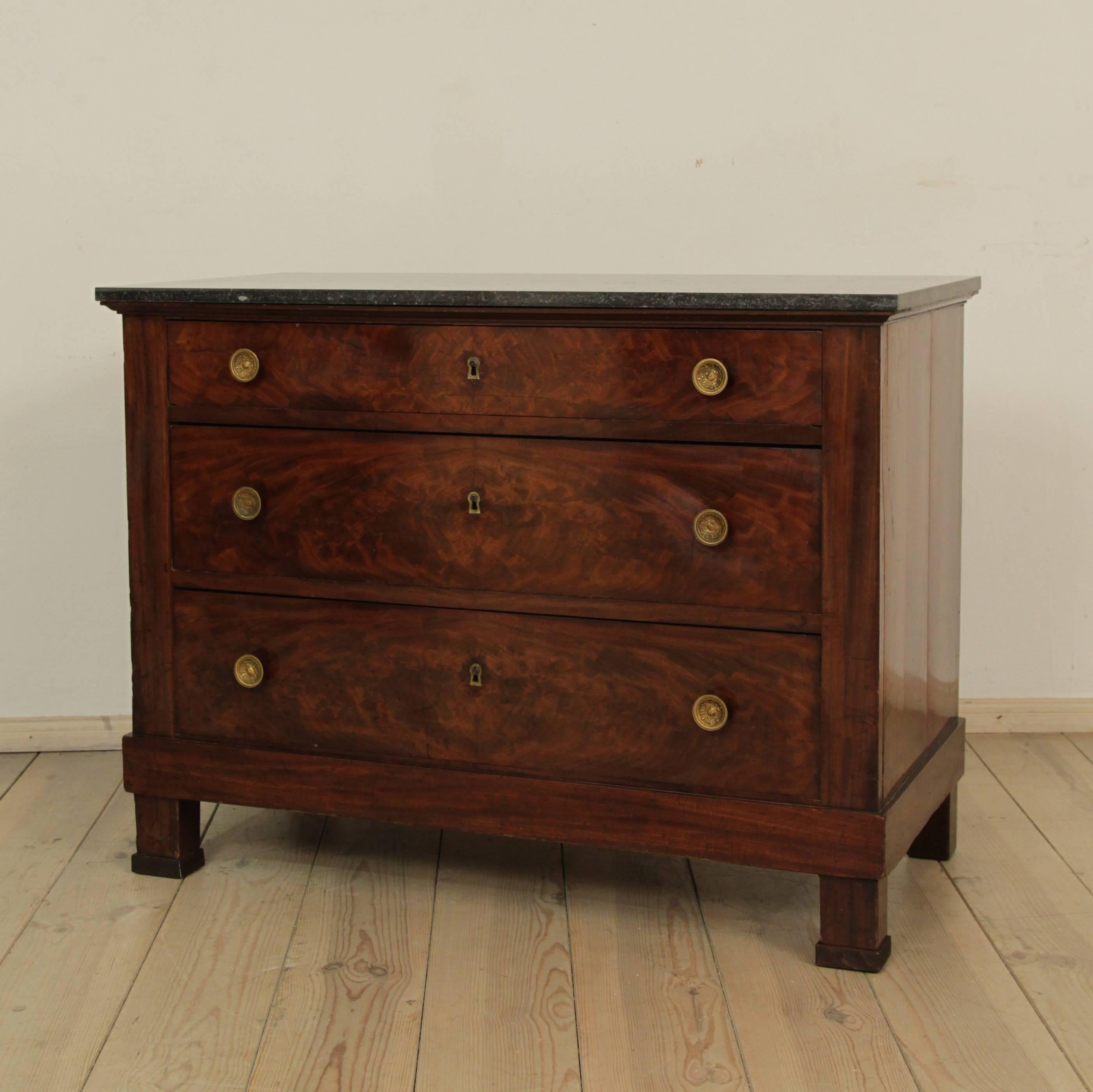 This French Empire commode is circa 1800. It is mahogany on oak with the original fittings and a later marble-top. The keys are missing. It is in a very good original condition.
