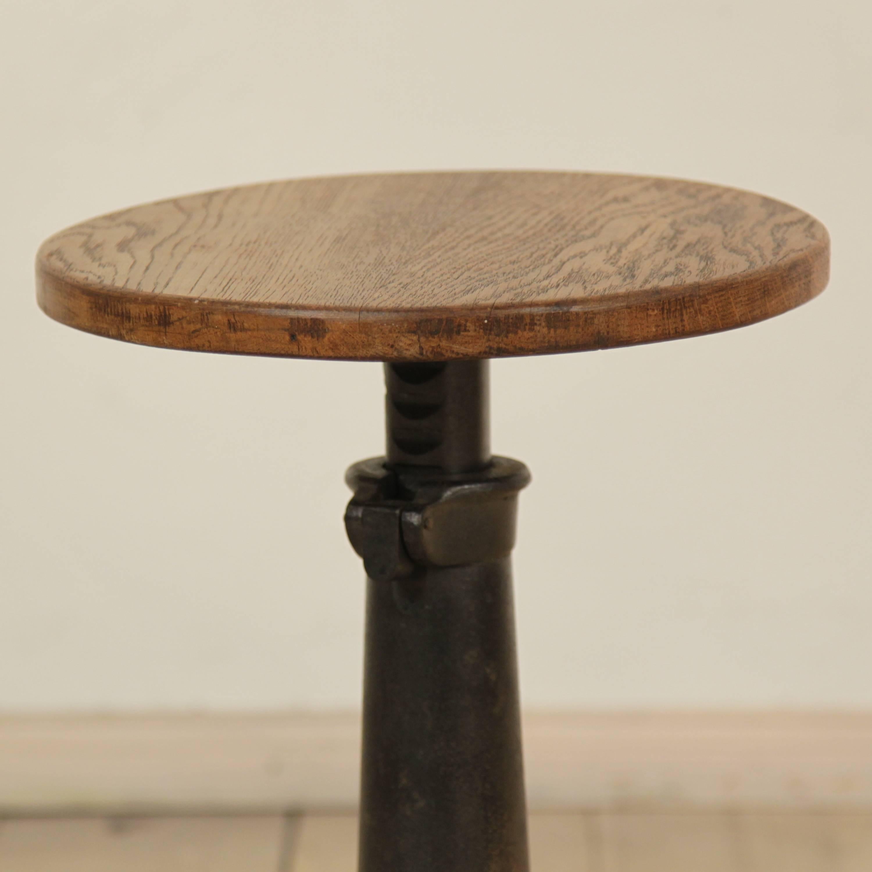 This German Industrial stool is from, circa 1920. It has a metal base and an oak seat. The remarkable foot shows lion feet. The stool is adjustable in height form 43cm - 59cm.