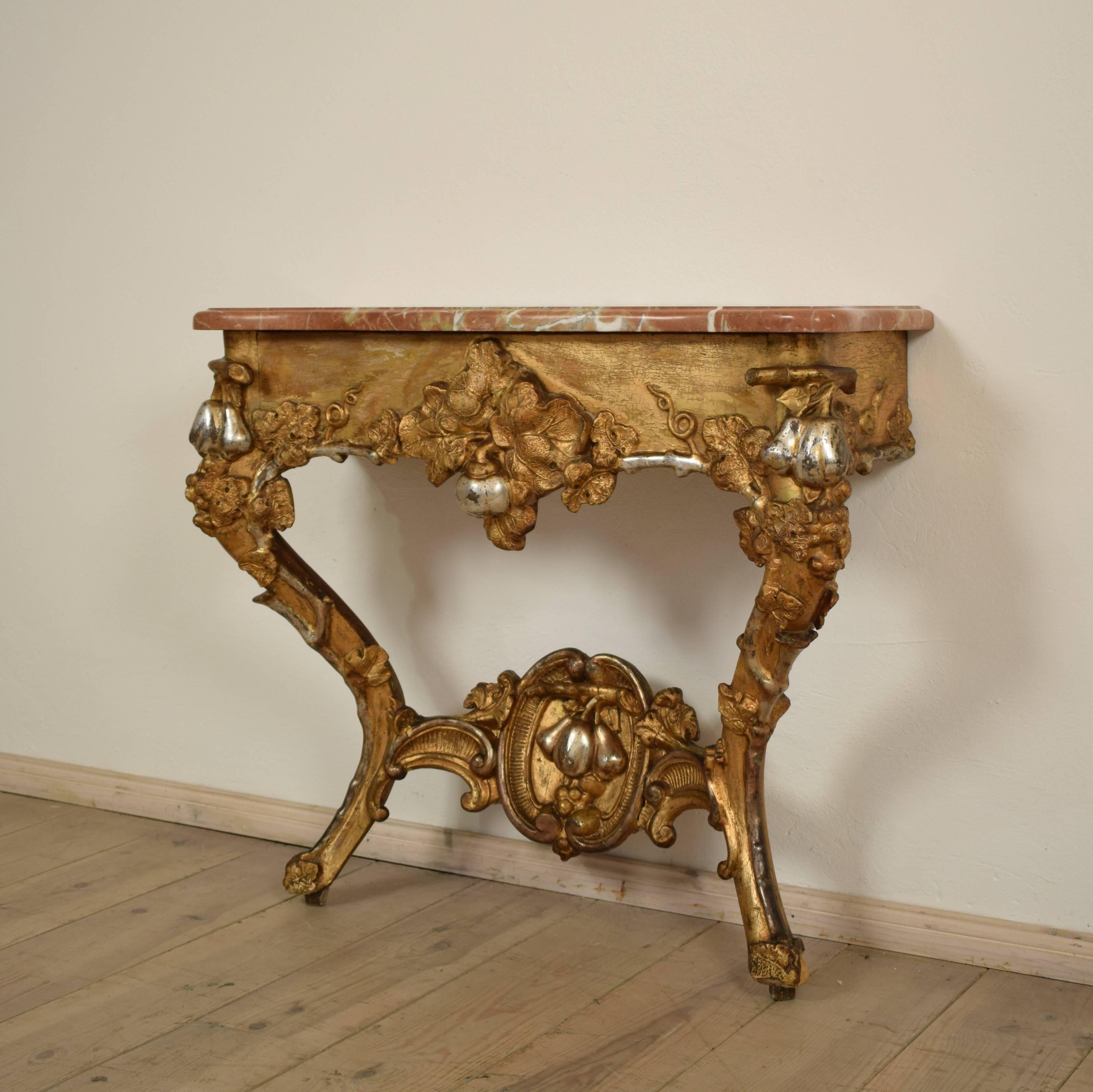 This small German console table is a real eyecatcher. The wooden base is beautifully carved and moulded and then water-gilded and silvered. It contains it original gilding and has a great Patina.
The beautiful red marble top got replaced at some