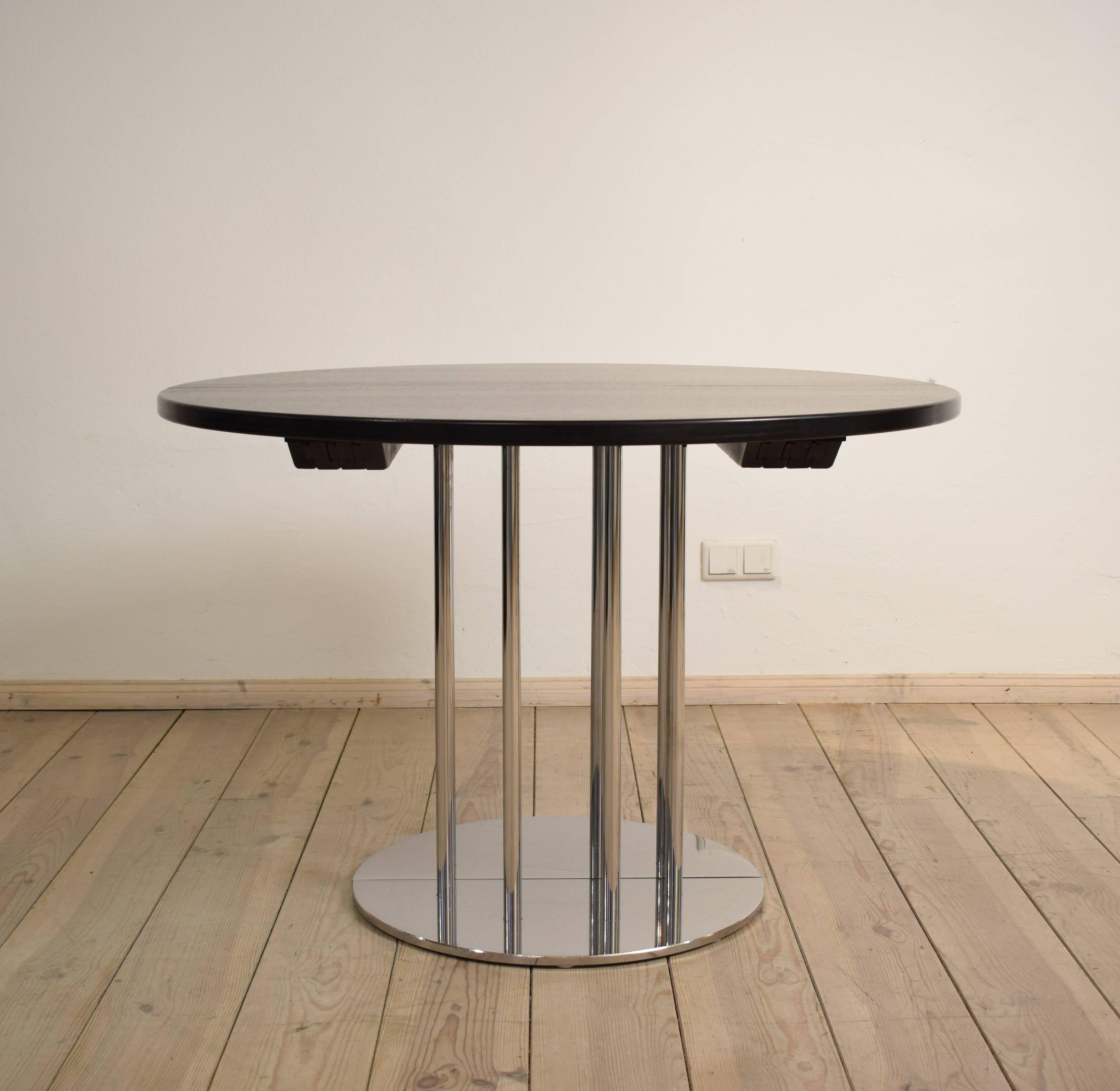 This extendable dining table was designed and manufactured in the 1986 by Thonet.
The table has a solid and valuable chrome-plated base and a massive blackened oak top. A very high quality worked table.
The top comes with two inlay leaves and can be
