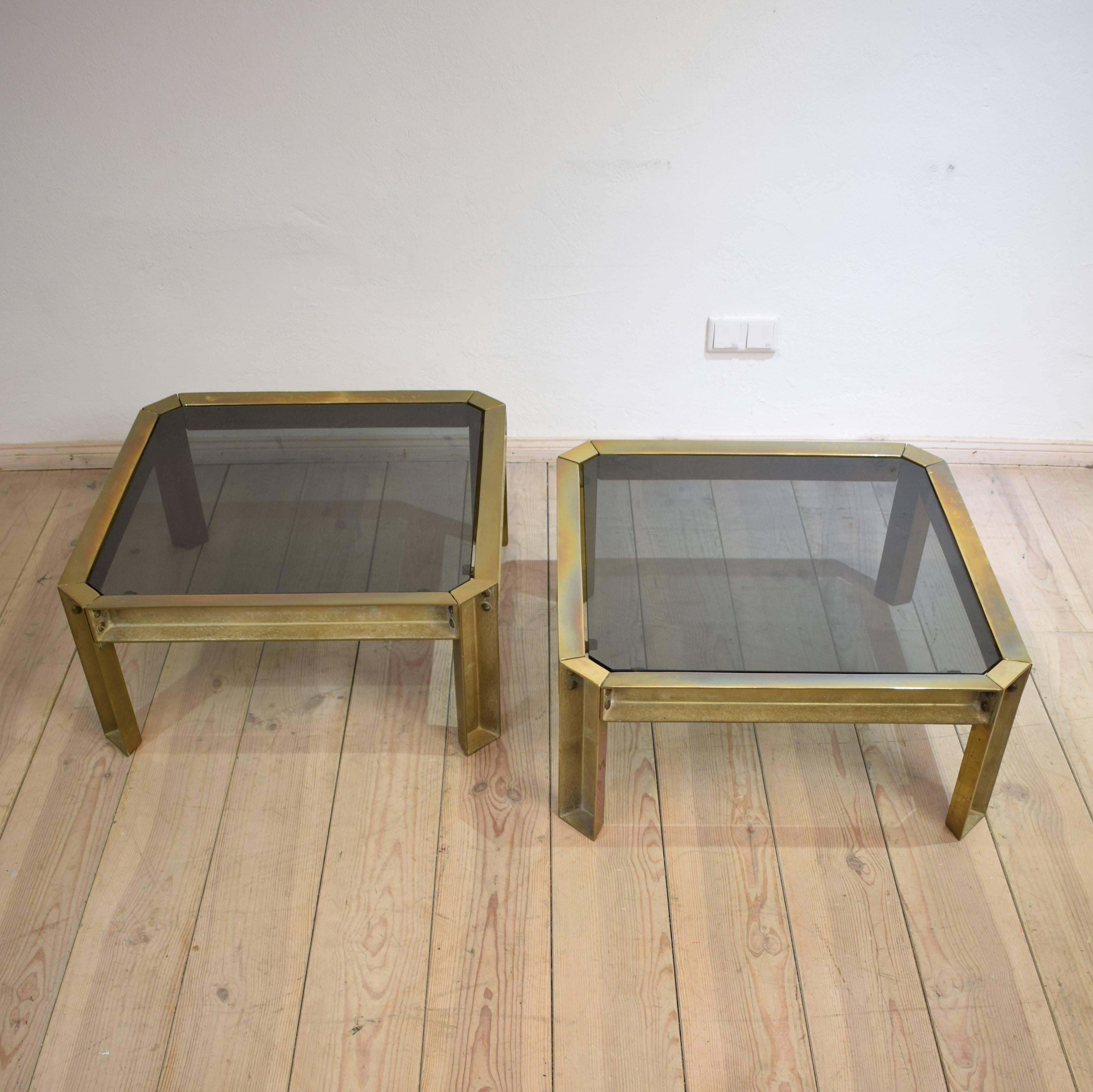 This rare pair of casted brass coffee tables with smoked glass top was made and designed by Peter Ghyczy in the 1970s.
It has a Brutalist unfinished exterior and polished sides and tops.