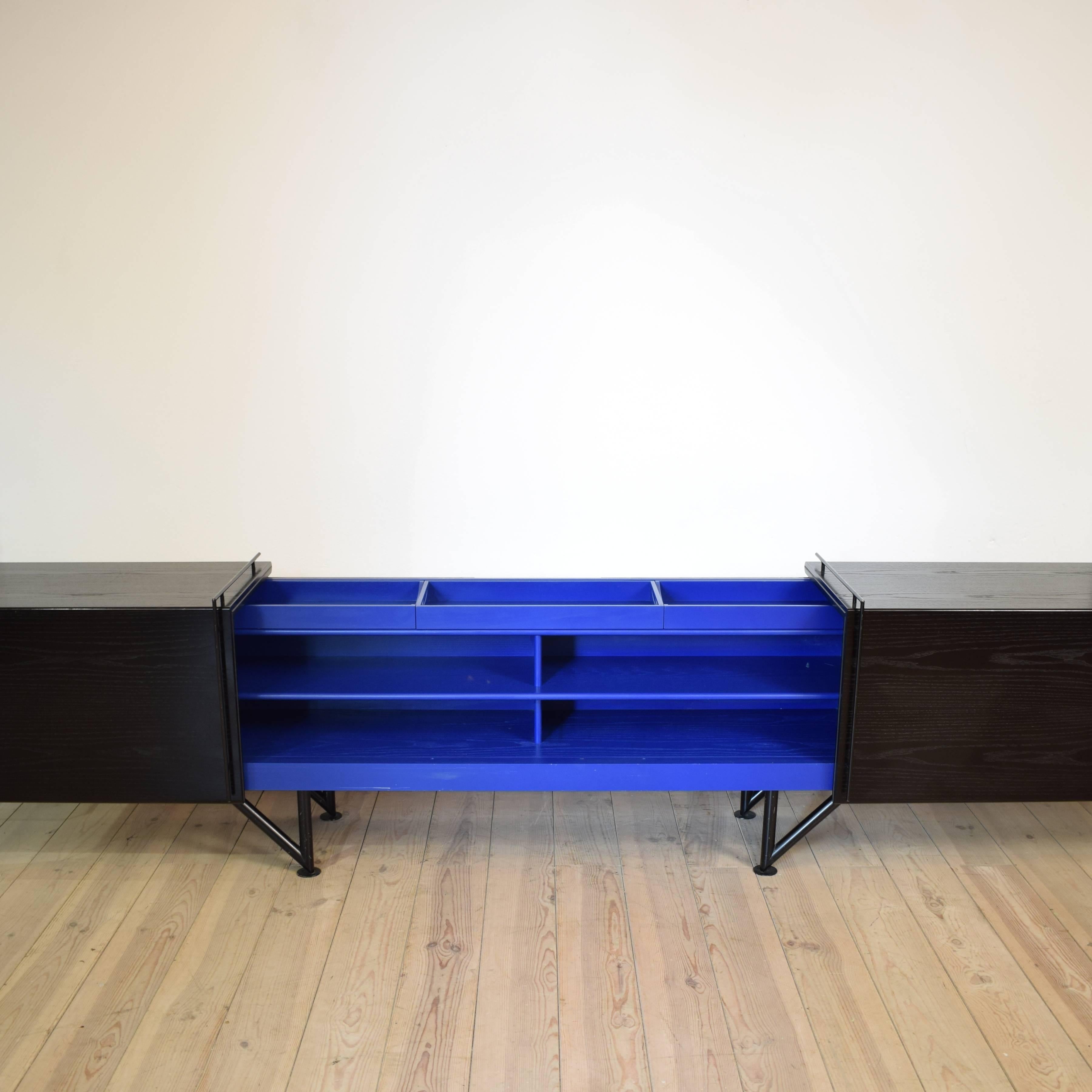 This Postmoderne sideboard was produced and designed in the 1980s. It is a prototype from a German designer.
The corpus is made out of oak veneer which is lacquered black and blue.
You can slide the doors the sideboard on both sides that it expands