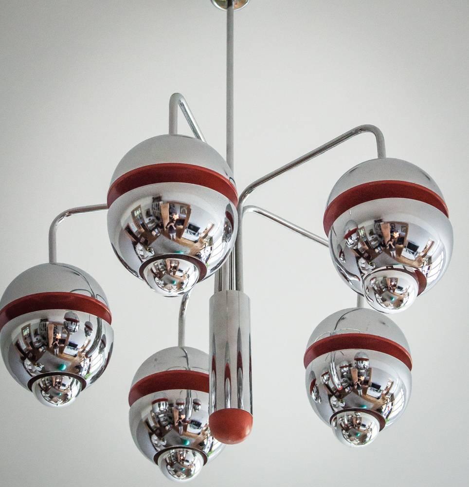
This beautiful Kaiser Spage Age chandelier, designed by Klaus Hempel, winner of the IF Design Award of the 1970s.
These five chrome metal shades have an orange colored inlay wich makes the light warm and cosy and is in perfect condition.
Each