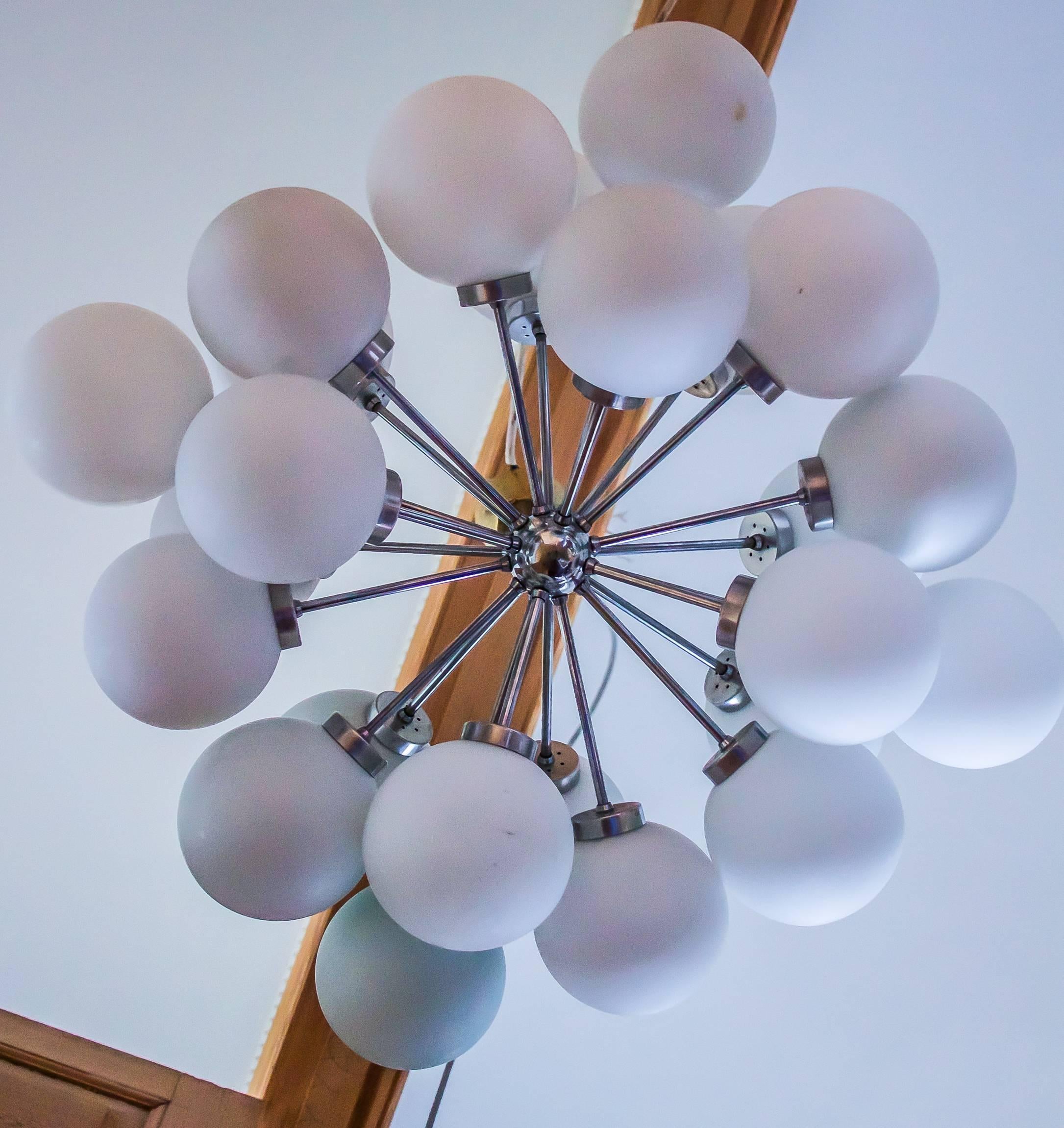 Great and very straight German Design by Richard Essig, from 1965, Space Age,
Twenty-four-light Starburst Sputnik chandelier in chrome. 

Large chrome chandelier with 24. Opaque glass lampshades. Gives a wonderful warm, shadow free light.