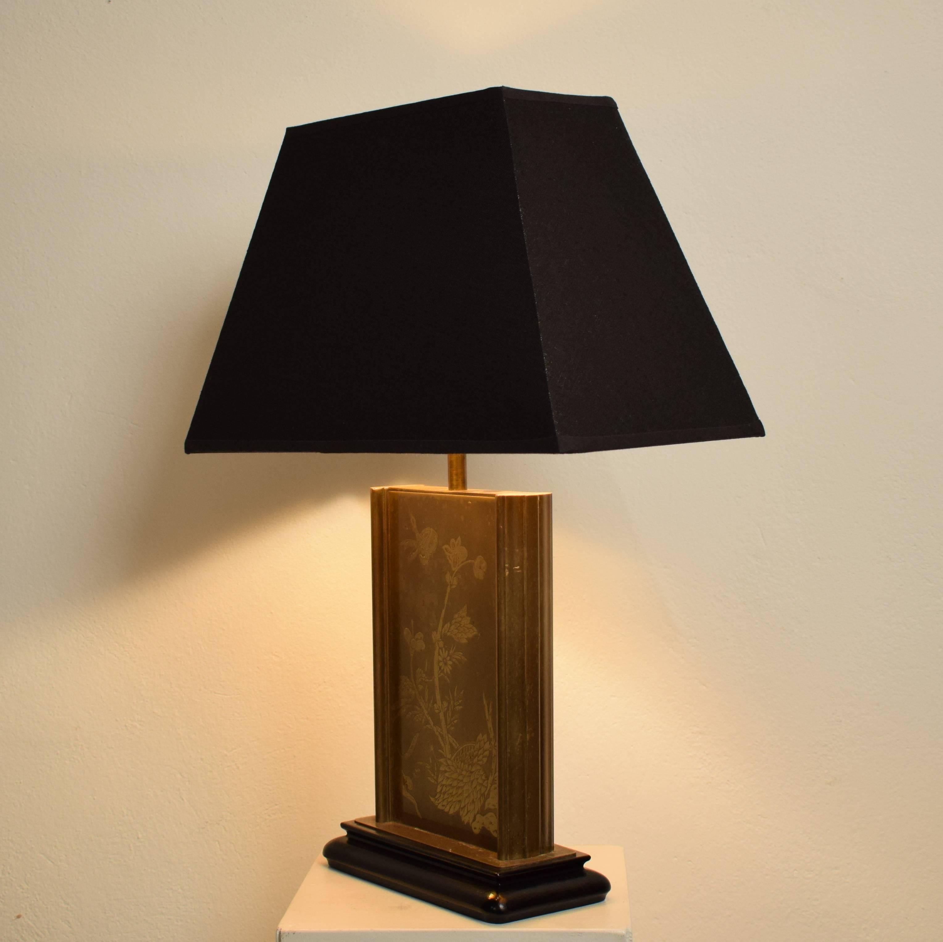 This French brass table lamp was produced around 1970. 
The brass is beautiful etched with flowers and insects. The base is made out of solid wood which is ebonies.
The shade is later.
(The measurements are with the shade)
A great decorative piece