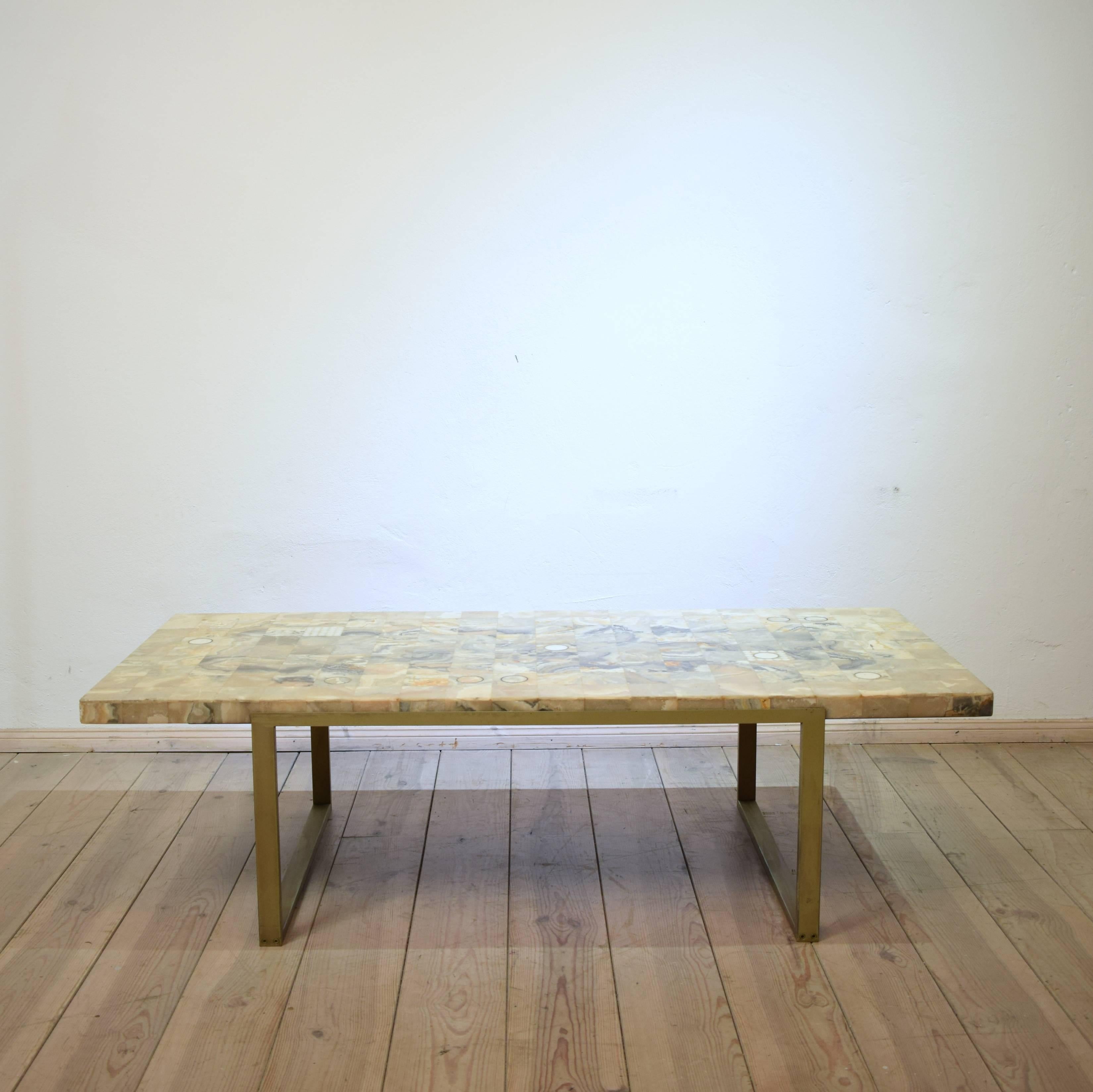 This marble coffee table from Germany, from circa 1970, has a marble mosaic with brass inserts top on a metal frame.
The marble comes in different colors like white, brown, beige and some reddish tones.
A great piece of furniture which fits in