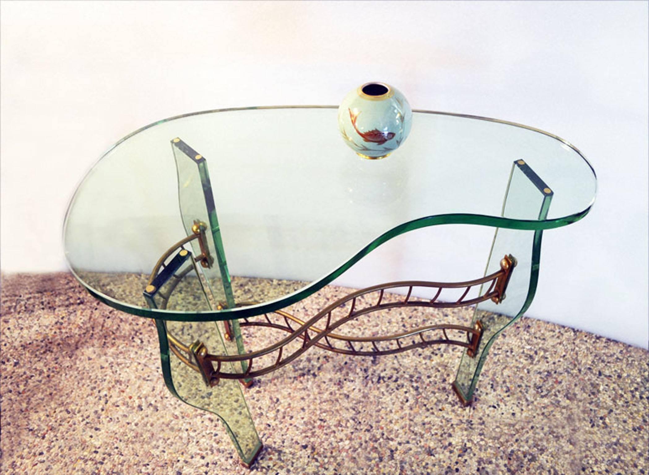 Table design Pietro Chiesa for Fontana Arte, 1940s.
Legs and top in shaped thick glass, brass structure and feet.